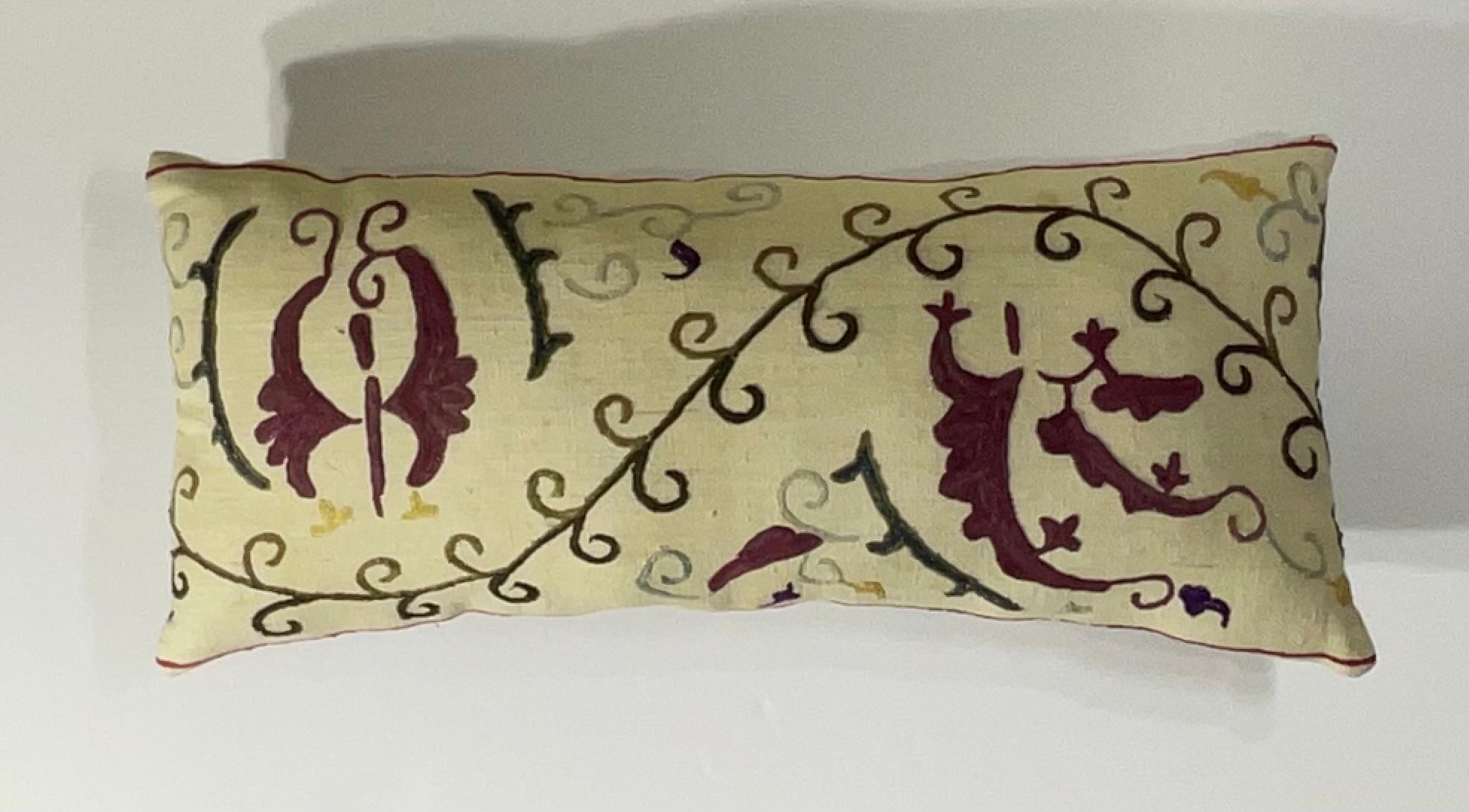 

This beautiful Suzani pillow is a true treasure, showcasing the artistry and craftsmanship of the past.  Hand embroidered with intricate floral and geometric motifs, this pillow is a testament to the skill and dedication of the artisans who
