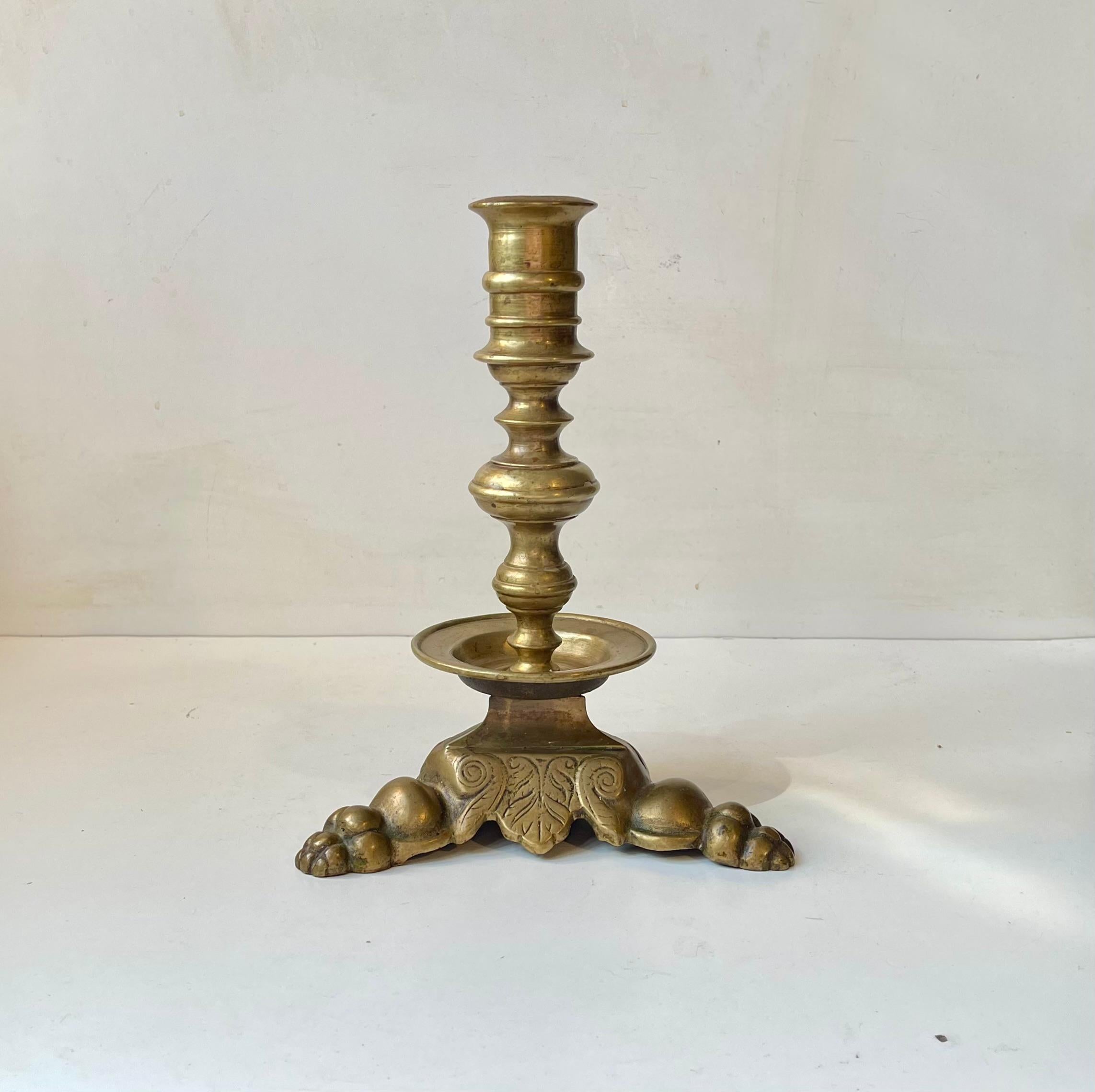 Heavy hand-engraved tri-stand altar or church candlestick on lions feet. It was made in Scandinavia from solid brass. It has no markings and its precise provenance is unknown. It is to fitted with a church/ 3 cm (diameter) candle or with a regular