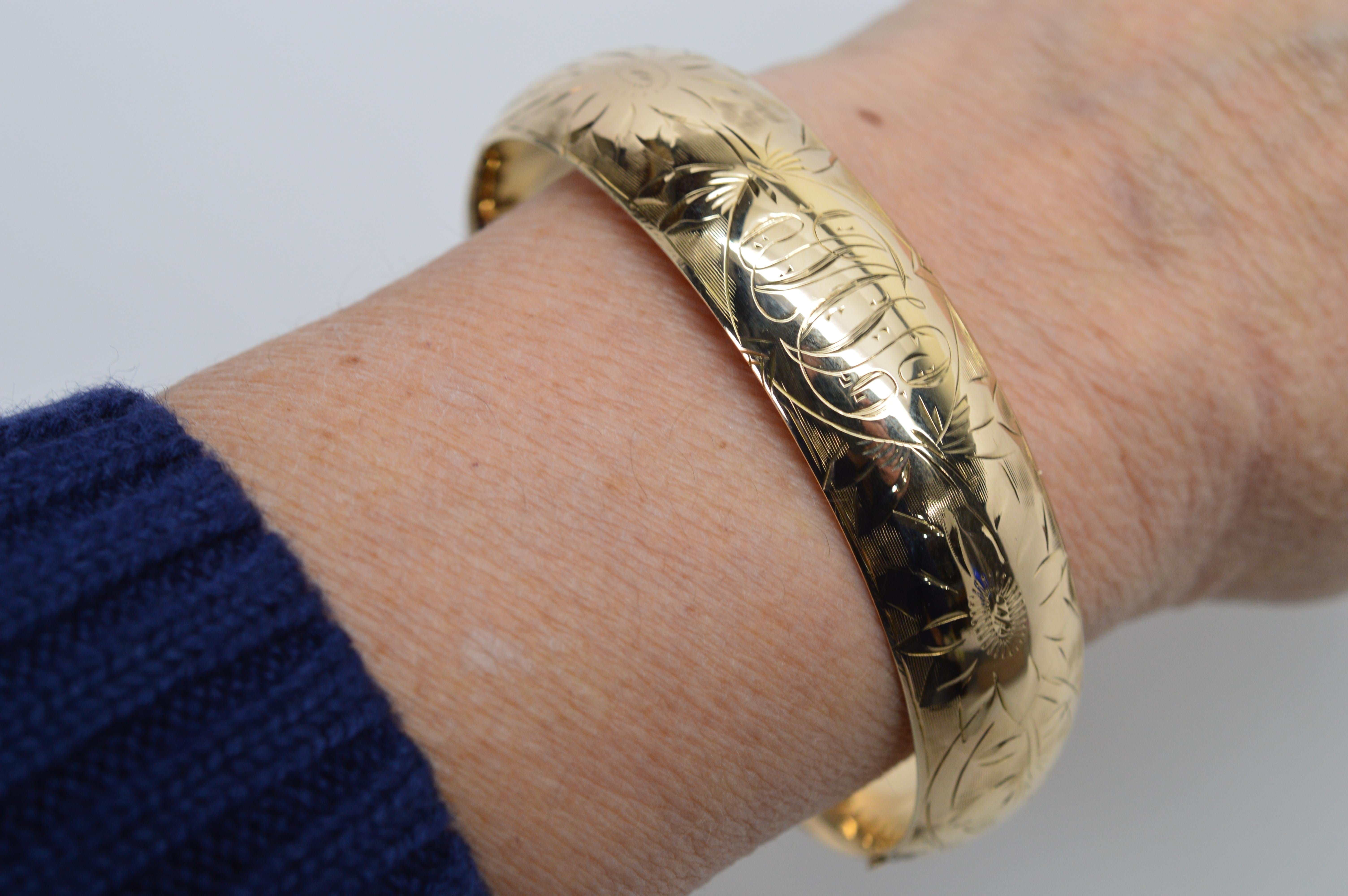 Hand engraving floral design and fancy script personalization adorn this antique fourteen karat 14K yellow gold bangle bracelet dated 1916, and signed by the maker of the period G&B. At 3/4 inch wide, the band of the bracelet has an engraved front