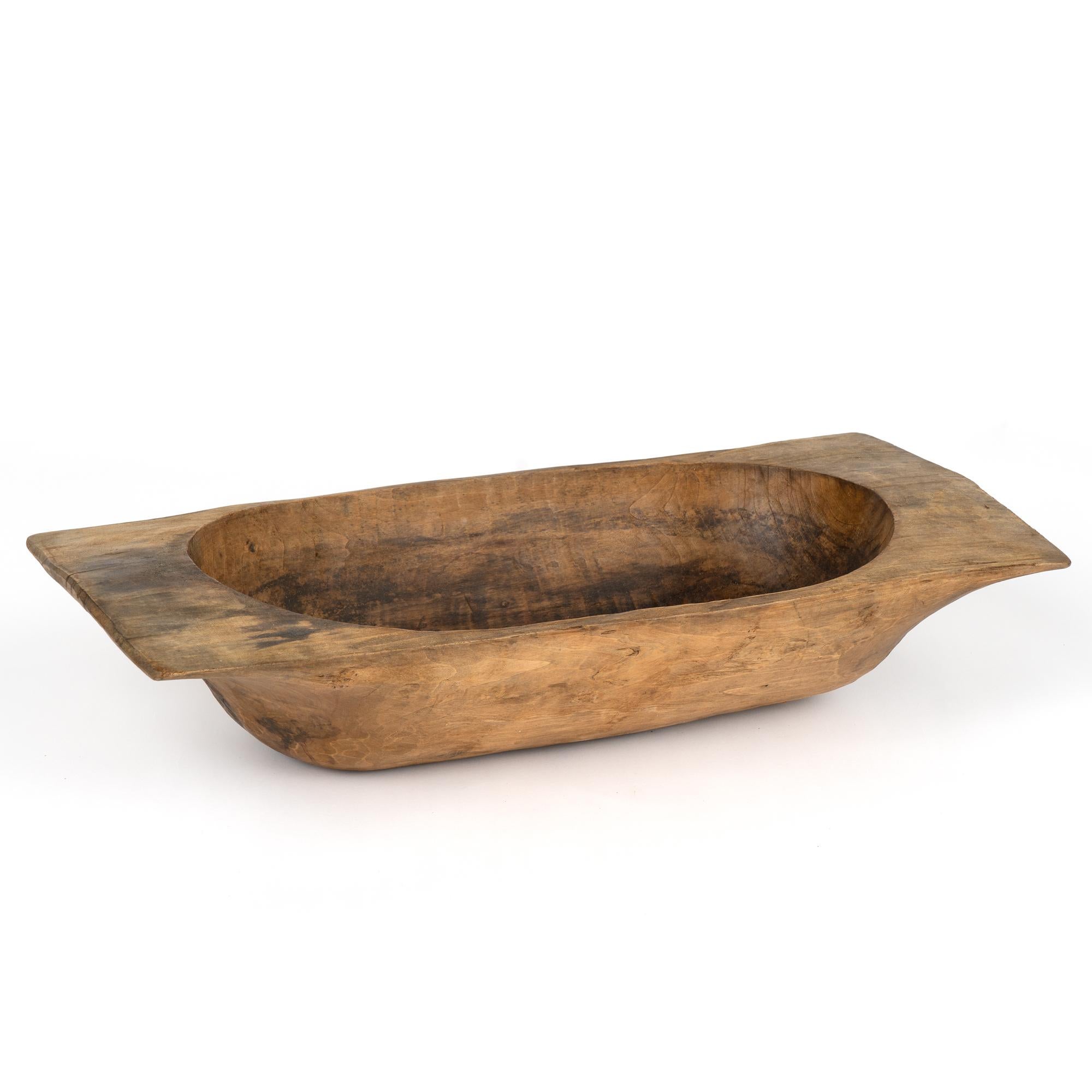 Antique, hand hewn, European country dough bowl / trencher featuring a rounded rectangular shape, tapered base and handles.
Old cracks, nicks, stains, distress are reflective of generations of use. 
Waxed and ready to use as decorative bowl.

With