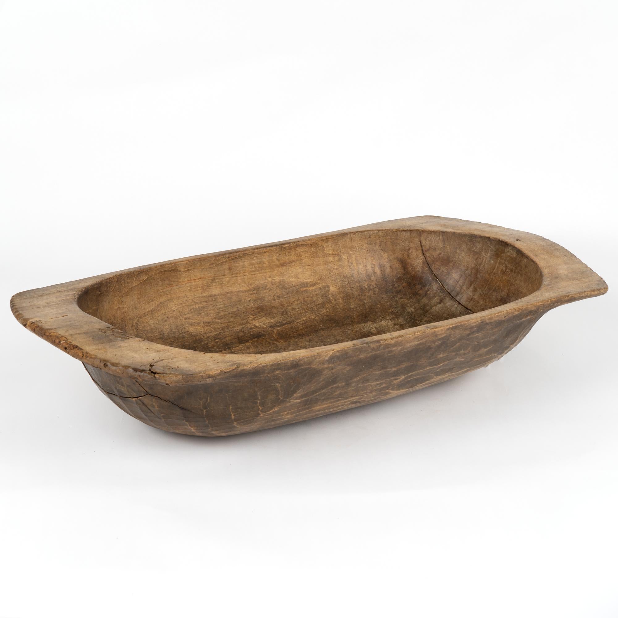Antique hand hewn, European country dough bowl / trencher featuring a rounded rectangular shape, tapered base and handles.
Old cracks/nicks, stains reflective of generations of use. Waxed, solid, stable and ready to be used as decorative bowl.

With
