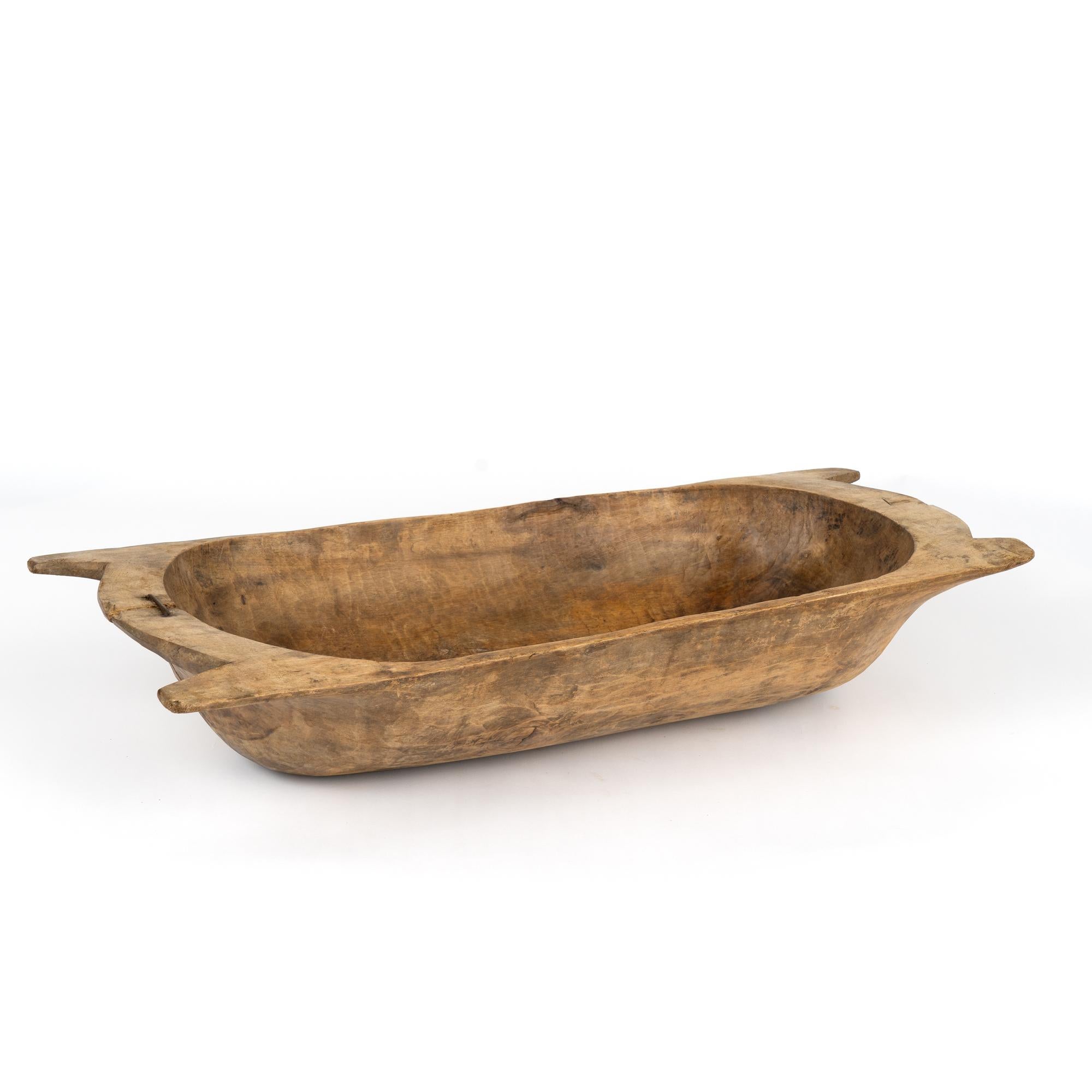 Antique, hand hewn, European country dough bowl / trencher featuring a rounded rectangular shape, tapered base and handles.
Old cracks, nicks, stains, distress are reflective of generations of use. Old repair using nail/large staple to secure
