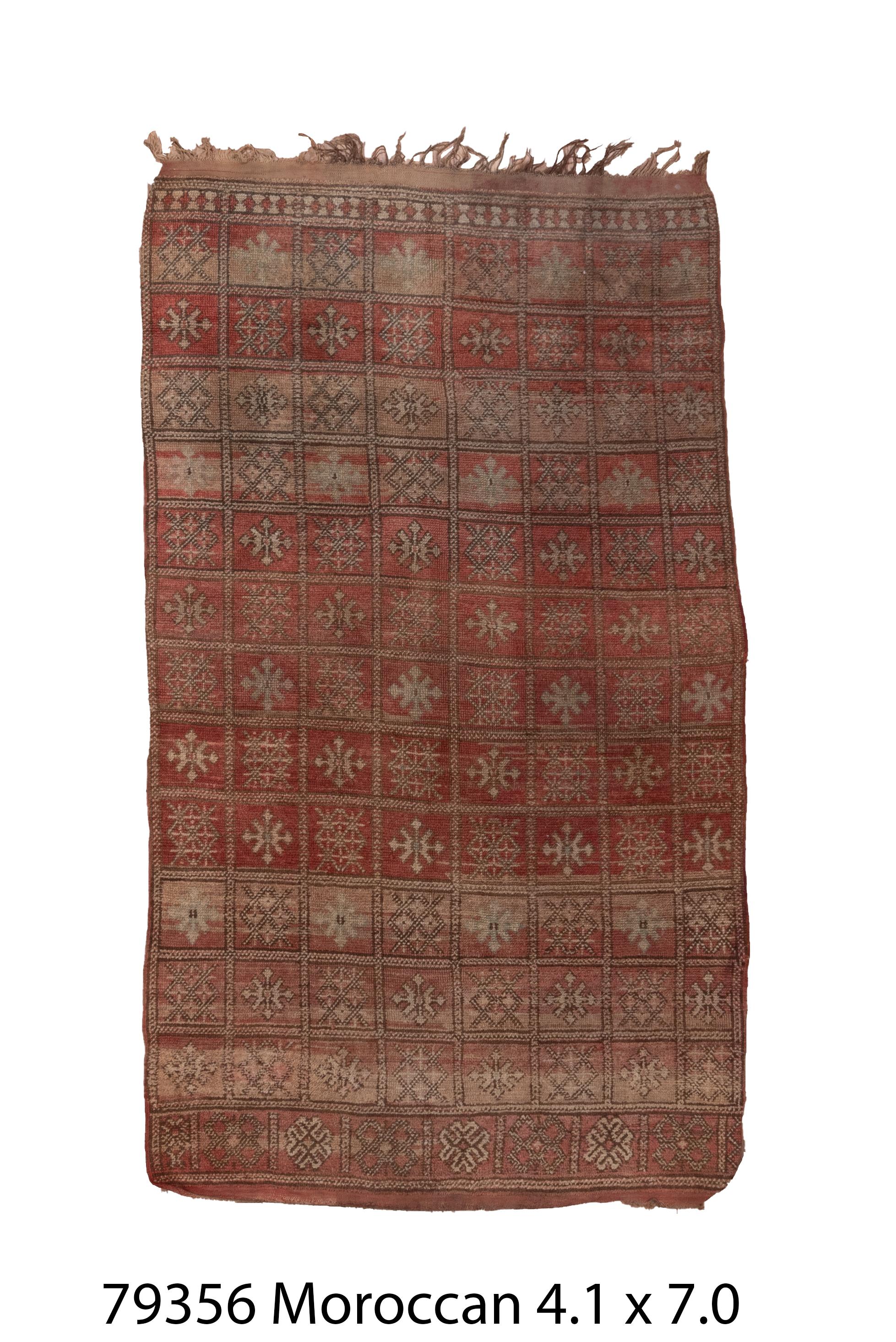 This antique Anatolian rug features a repeating grid of stylized stars and floral medallions in softened shades of terracotta, taupe, and charcoal. Hand-knotted with a low wool pile, its worn patina and symmetrical layout evoke rustic elegance and