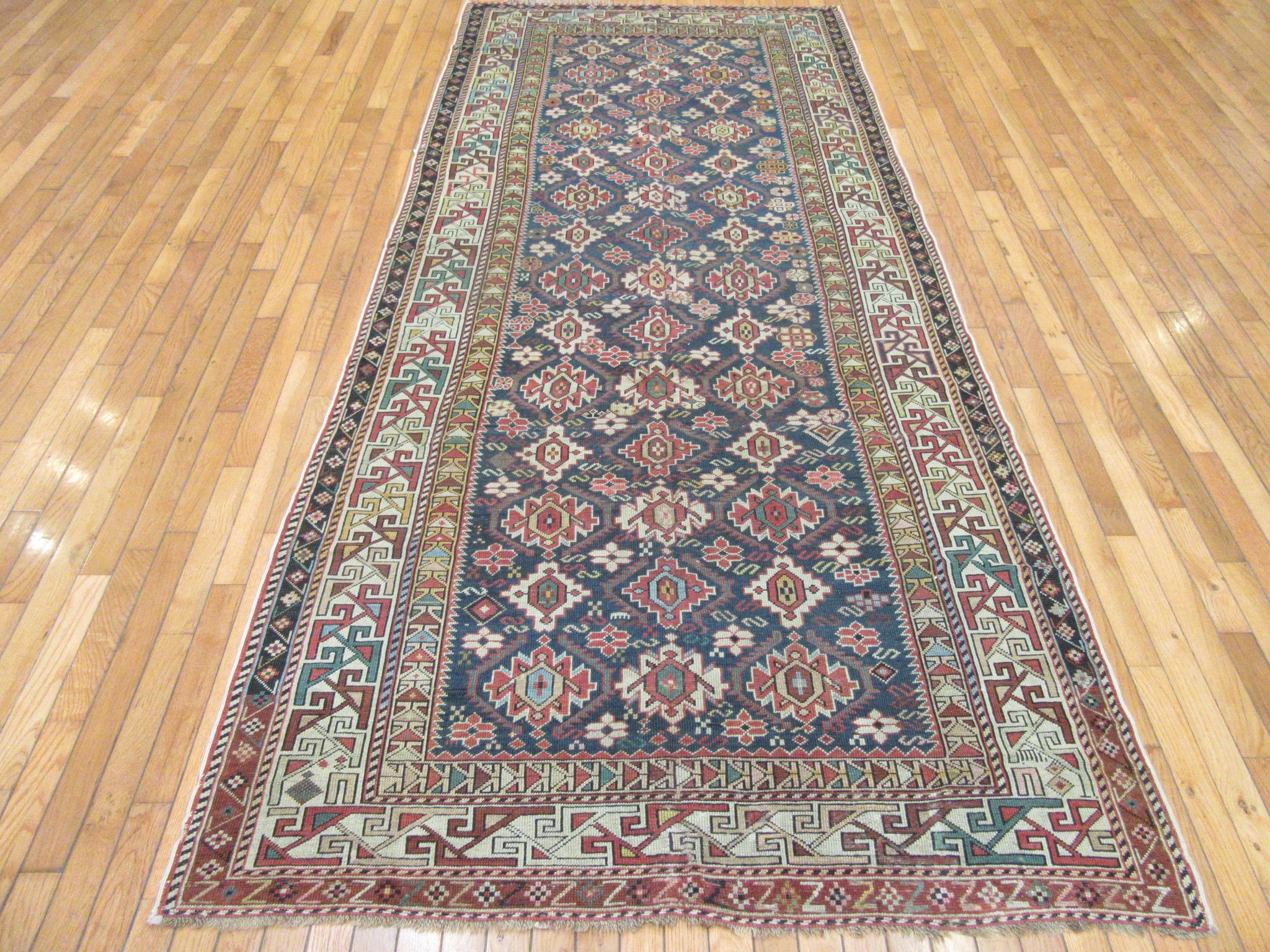 This is a finely hand knotted antique gallery size rug form the caucuses. It has the traditional geometric all-over pattern on a blue color field. The rug is a perfect choice for an entry, wide hall or any room in your house or office. The rug