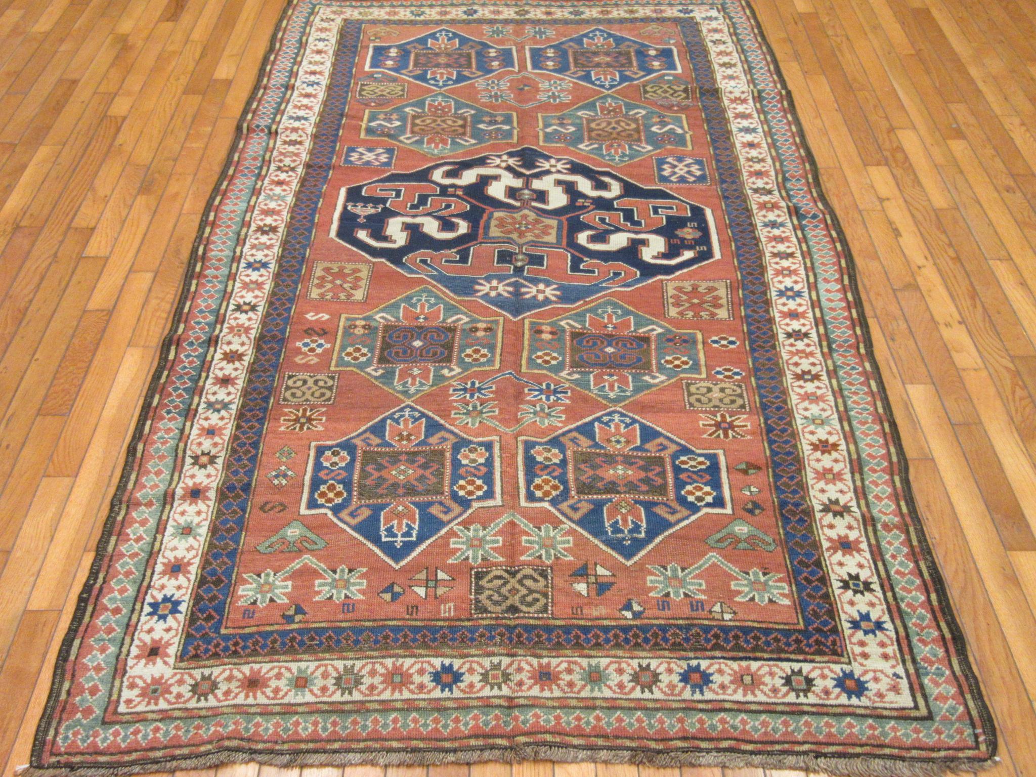This is an antique hand knotted Caucasian rug made in the village of Kazak. It is made with wool colored with natural dyes. It has a traditional multi medallion geometric pattern on a rusty red color field. The rug measures
4' 8'' x 8' and in very