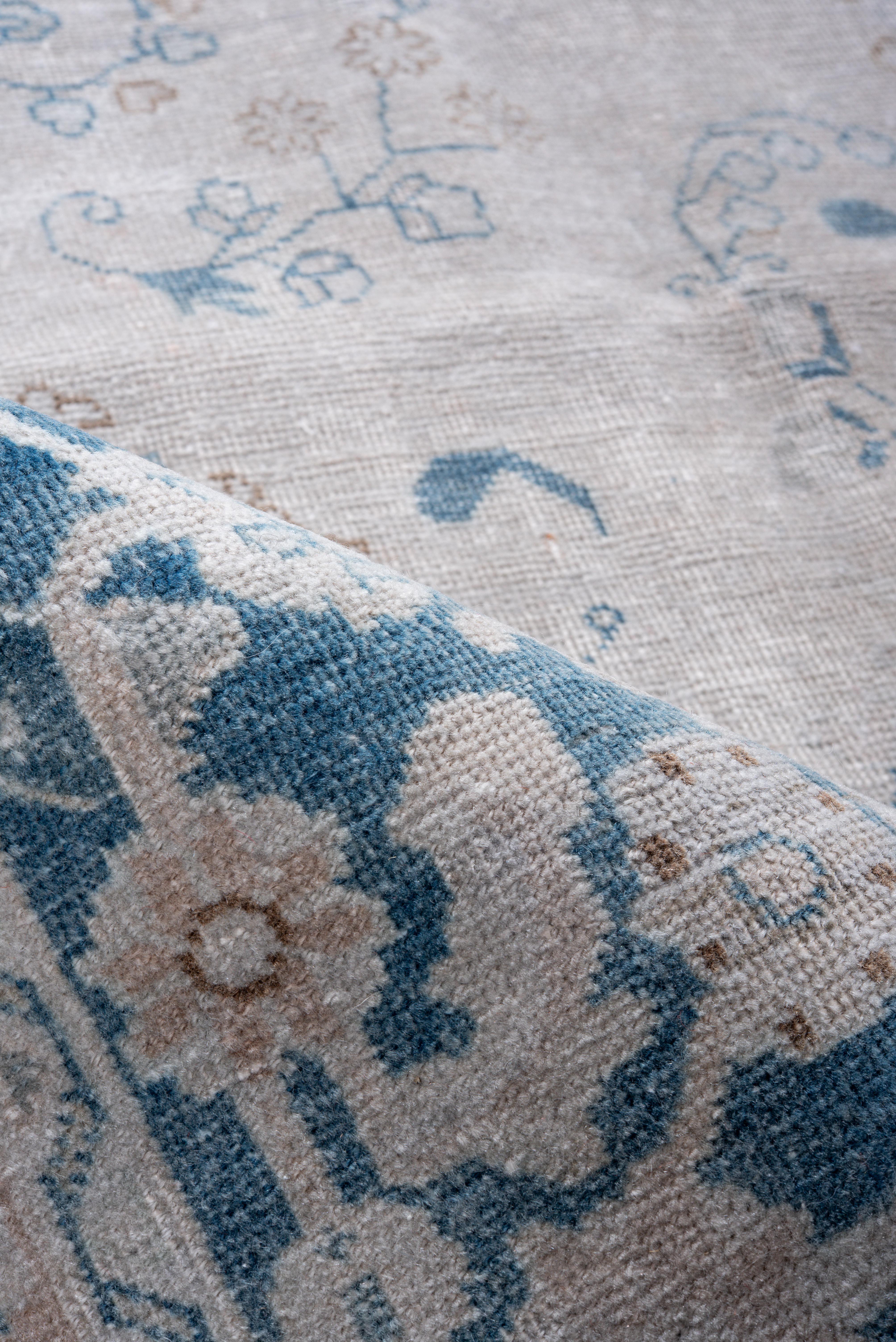 Dieser antike Mesh-Teppich zeichnet sich durch ein elegantes Medaillonmuster aus, das in einer beruhigenden Farbpalette aus sanftem Elfenbein, verblasstem Indigo und warmem Beige gewebt ist. Die detaillierten floralen Motive und die sich windenden