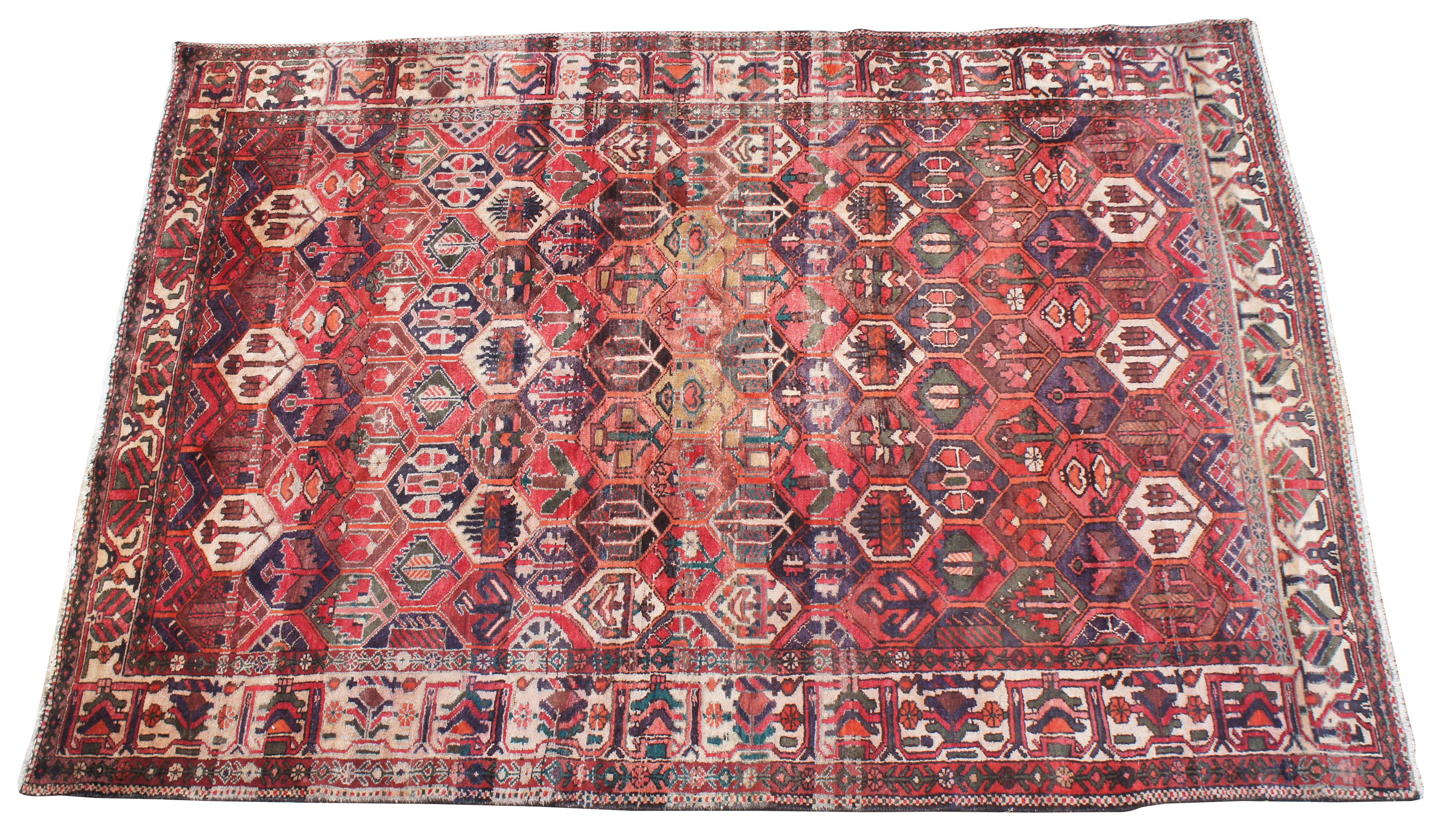 Fantastic antique hand knotted Persian Bakhtiar area rug. Inspired by Persian gardens with a field of red with a geometric floral pattern with greens, reds, tans, pinks, purples and orange. Measures: 7' x 10'.
   