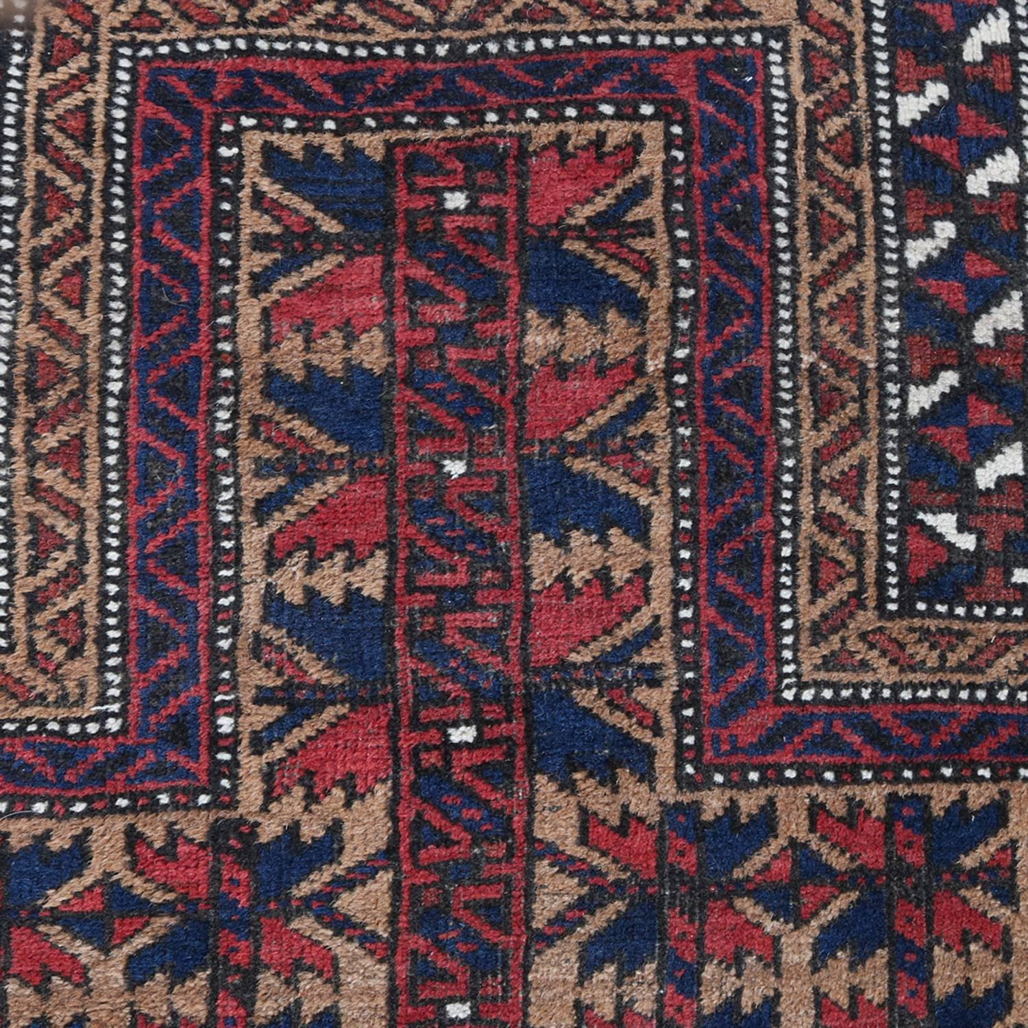 Antique hand-knotted Persian Baluch oriental prayer rug features traditional repeating geometric design, dominating colors include reds, blues, tans and ivory, 1900

Measures: 61