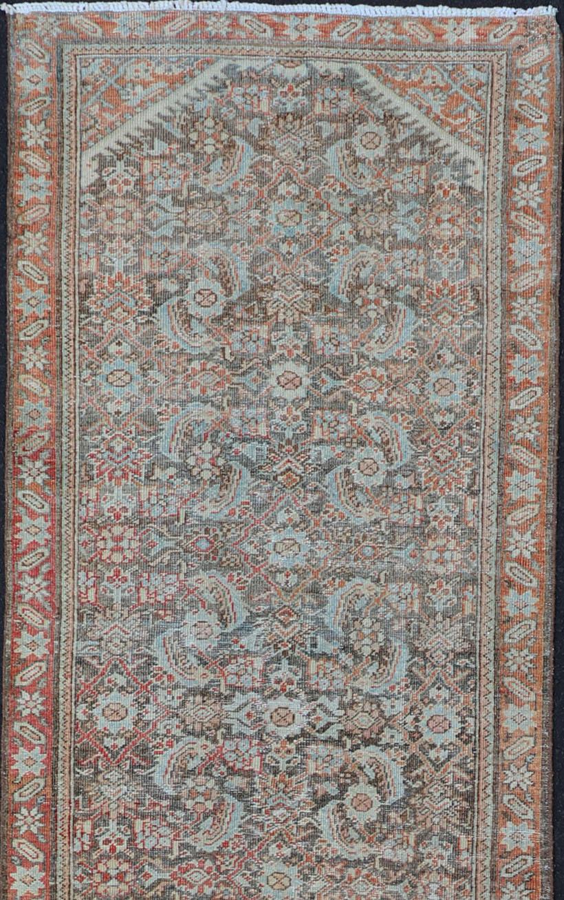 This antique hand-knotted Persian Hamadan runner features an all-over floral design centered in a large medallion and is enclosed within a complementary multi-tiered border. Rendered in multicolor; this rug is a perfect fit for a variety of classic,