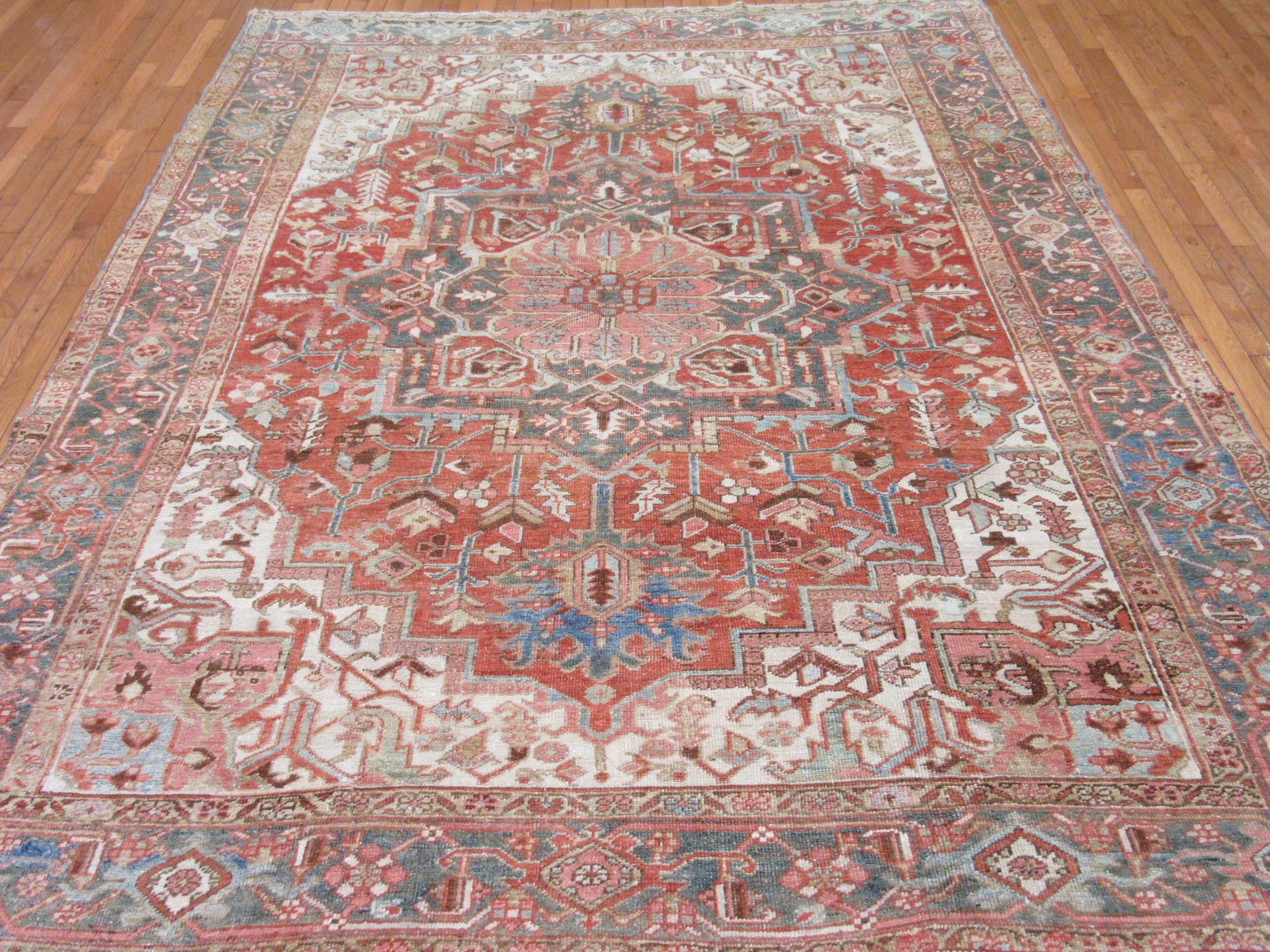 This is an antique hand-knotted Persian Heriz rug. It is made with wool on a cotton foundation. The rug has all naturals dyes and has been softened out for a mellow look for easy placement in your home or office. The rug measures 7' 6'' x 9' 6'' and