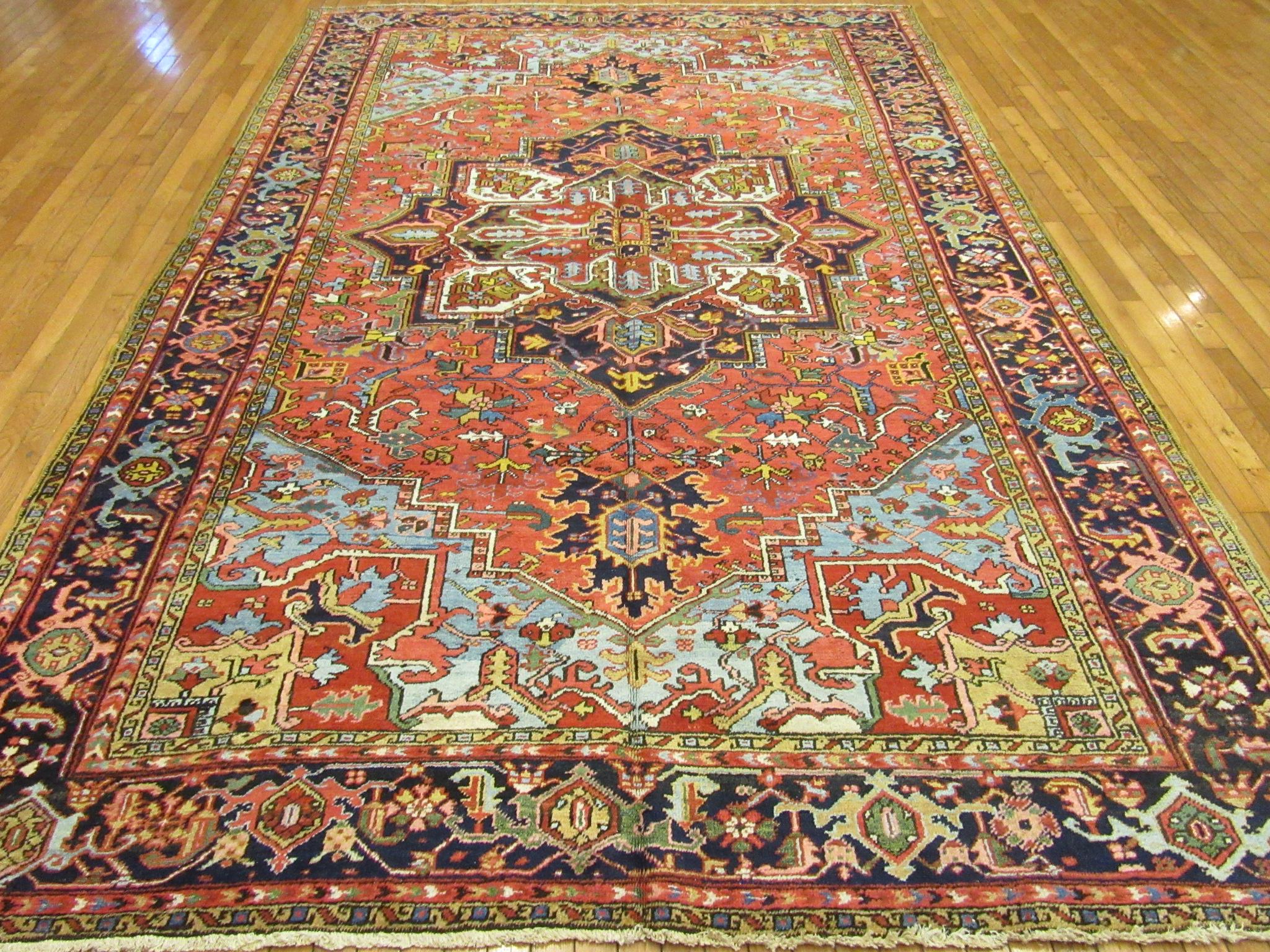 This is a beautiful hand-knotted antique Persian Heriz rug with bright happy colors made with wool and all natural dyes. The rug measures 7'8'' x 12' and is in great condition.