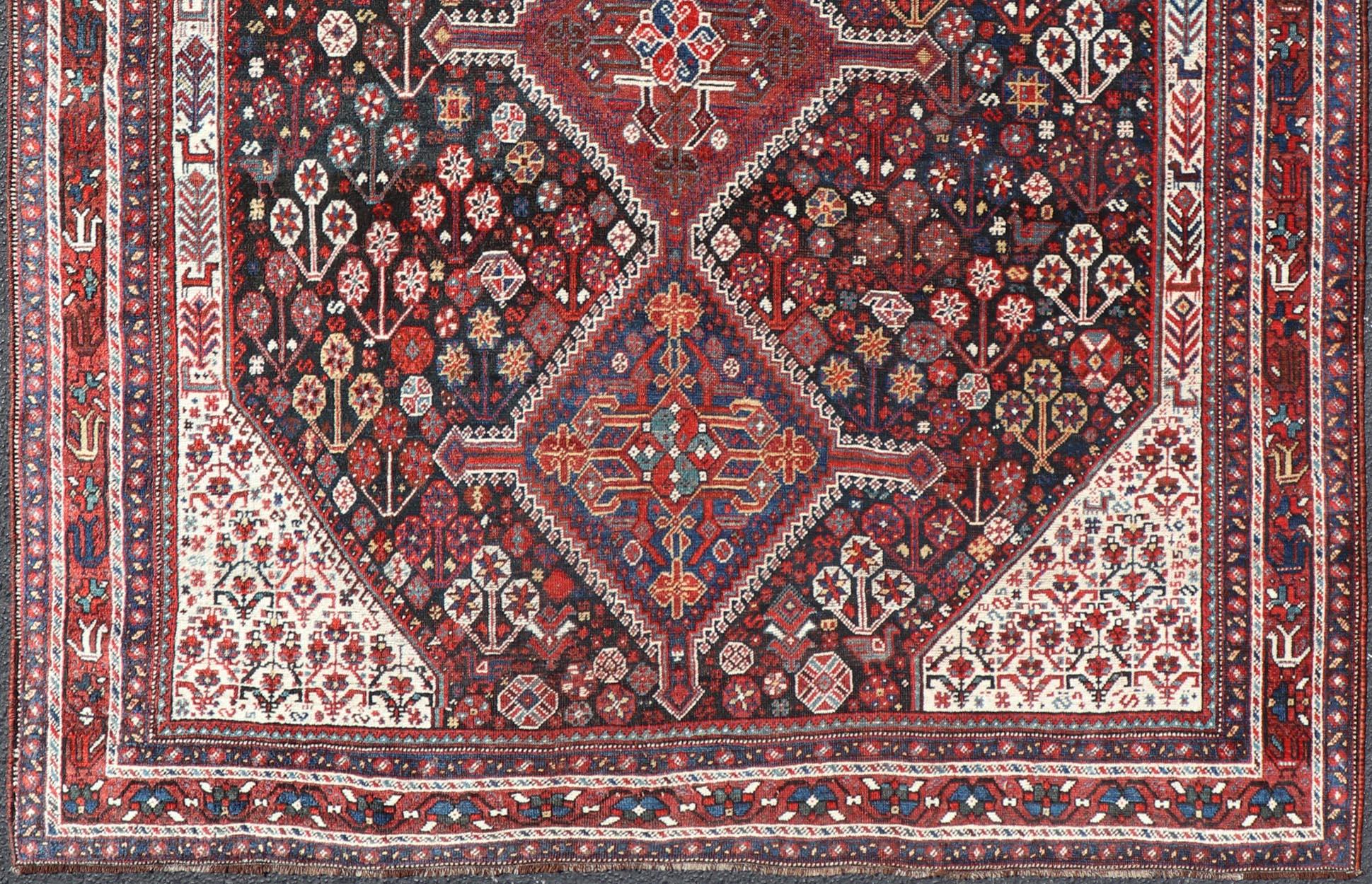 Tapis persan Qashqai ancien noué à la main en laine avec motif tribal sur toute sa surface en vente 1