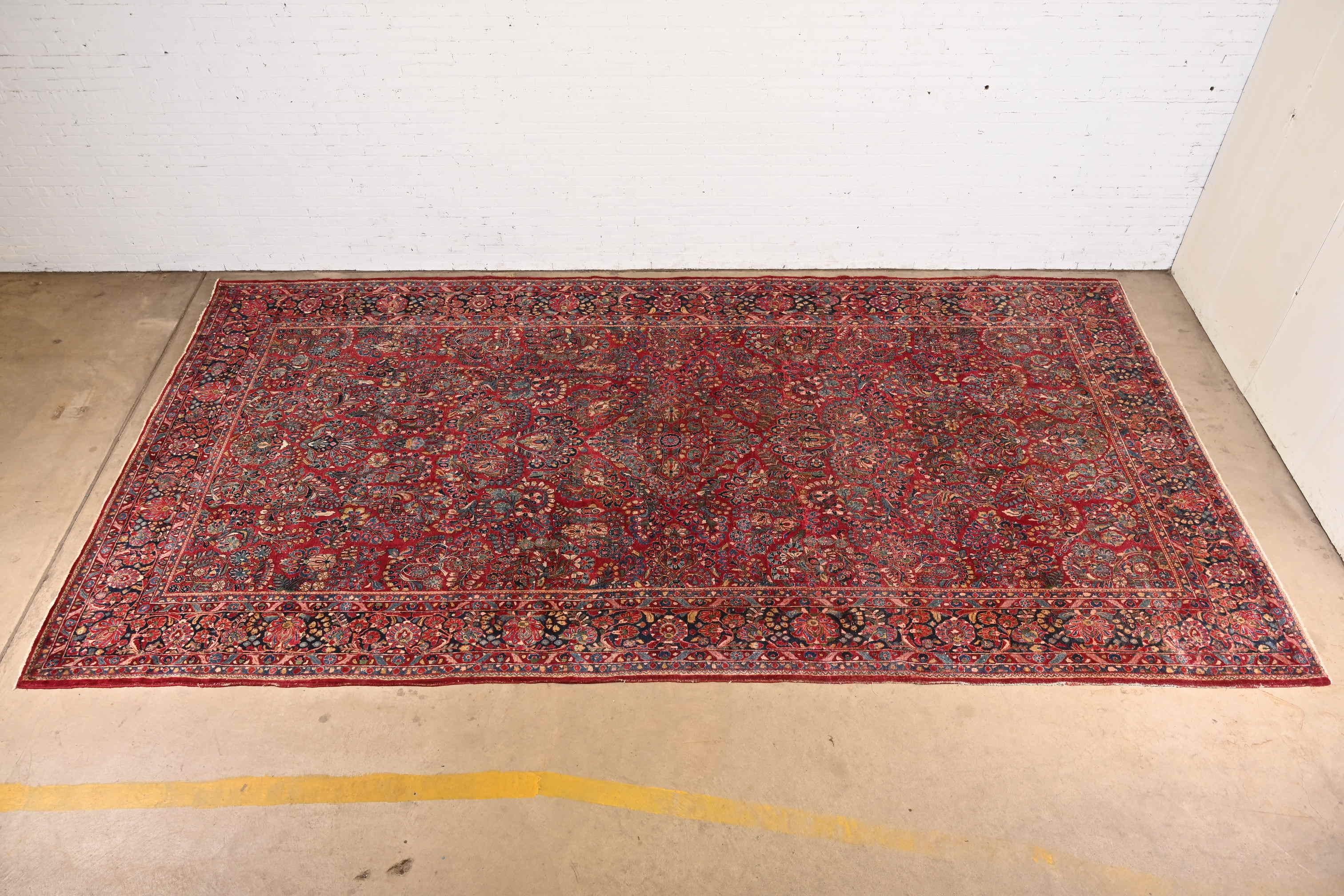 A gorgeous antique Persian Sarouk large room size rug

Circa 1920s

Features beautiful traditional floral sprays and bouquets, with predominant colors in red, blue, and ivory.

Measures: 9'11