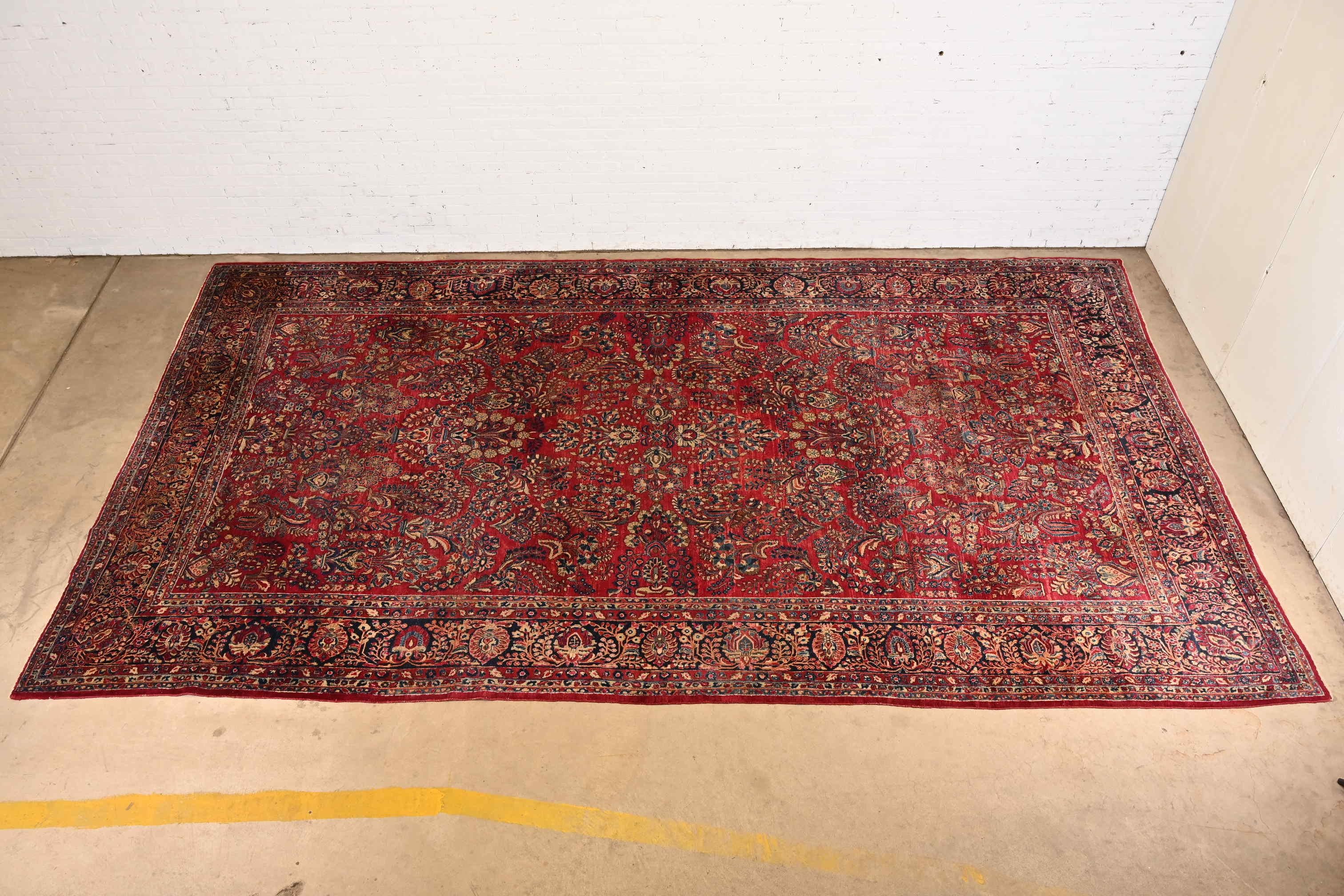 A gorgeous antique Persian Sarouk large room size rug

Circa 1930s

Features beautiful traditional floral sprays and bouquets, with predominant colors in red, blue, and ivory.

Measures: 10'2