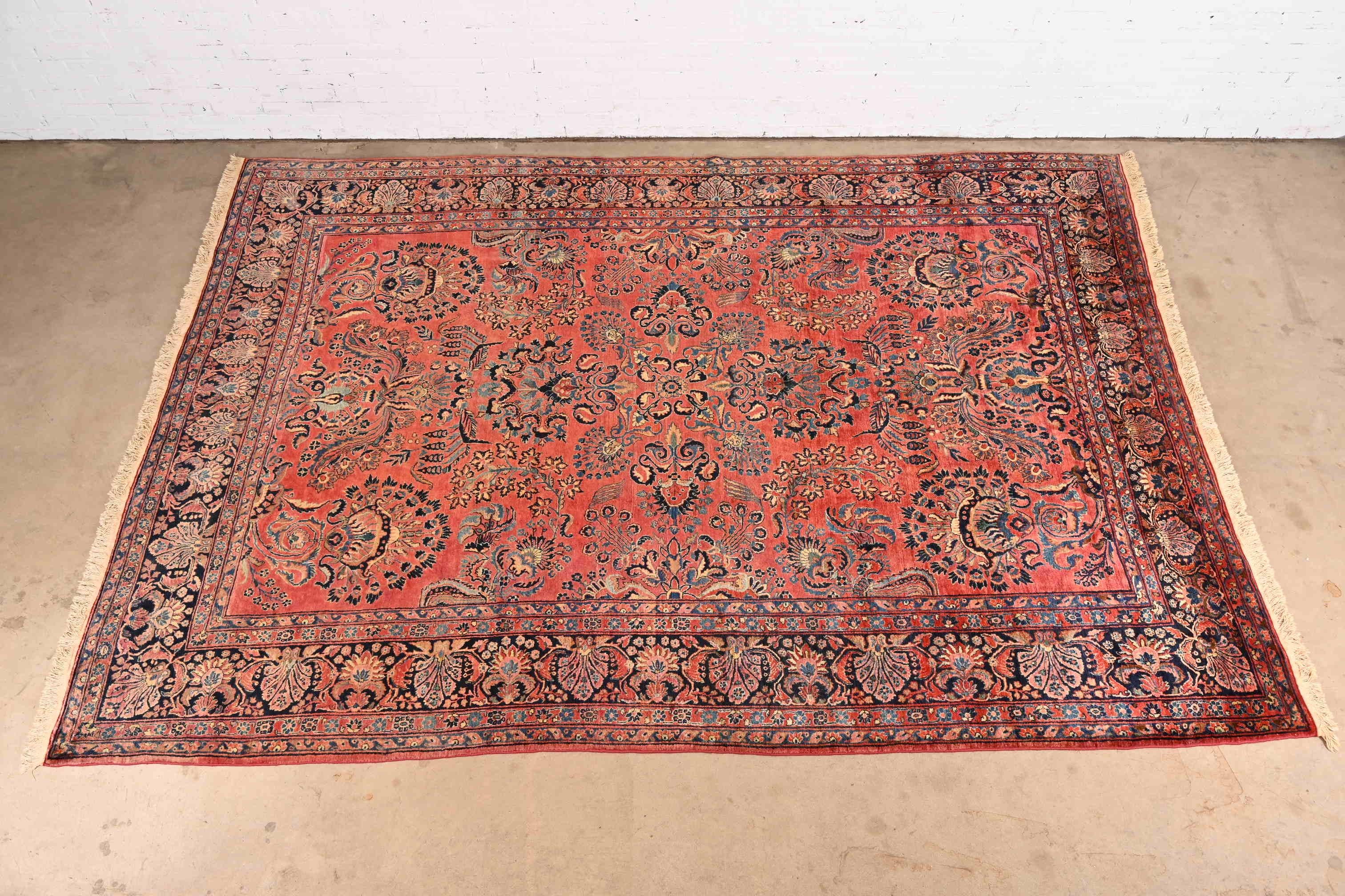 A gorgeous antique hand-knotted Persian Sarouk room size rug

Circa 1930s

Features beautiful traditional floral sprays and bouquets, with predominant colors in red, blue, and ivory.

Measures: 8