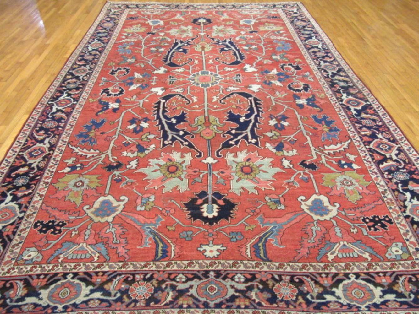 This is a large room size hand-knotted antique Persian Serapi rug with a rather all-over pattern design which provides flexibility with placement perfect for any room in your house or office. The rug has a fine weave not common in these type of
