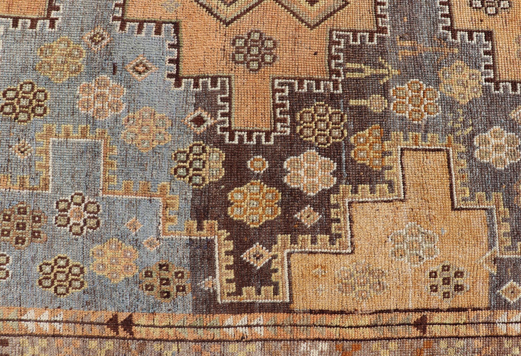 This antique Persian Shiraz rug has been hand-knotted in wool and features an all-over sub-geometric multi medallion design rendered in multicolor. A complementary, multi-tiered border encompasses the entirety of the piece; making it a marvelous fit