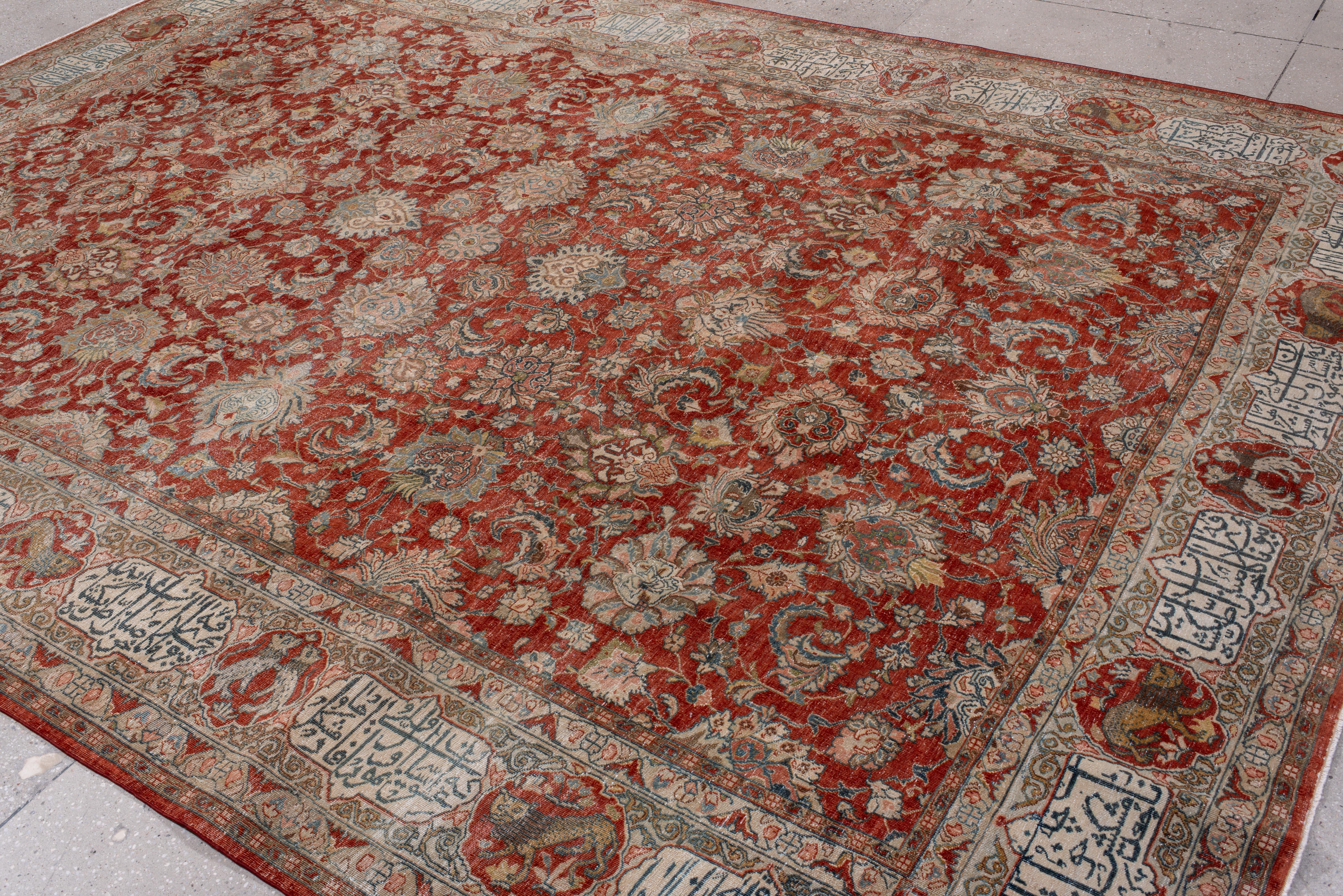 Questo antico tappeto Tabriz è un esempio straordinario di arte persiana, caratterizzato da un elaborato campo floreale in una profonda tonalità rosso ruggine, intessuto con delicati accenti avorio, blu tenue e oro tenue. I dettagli delle viti e