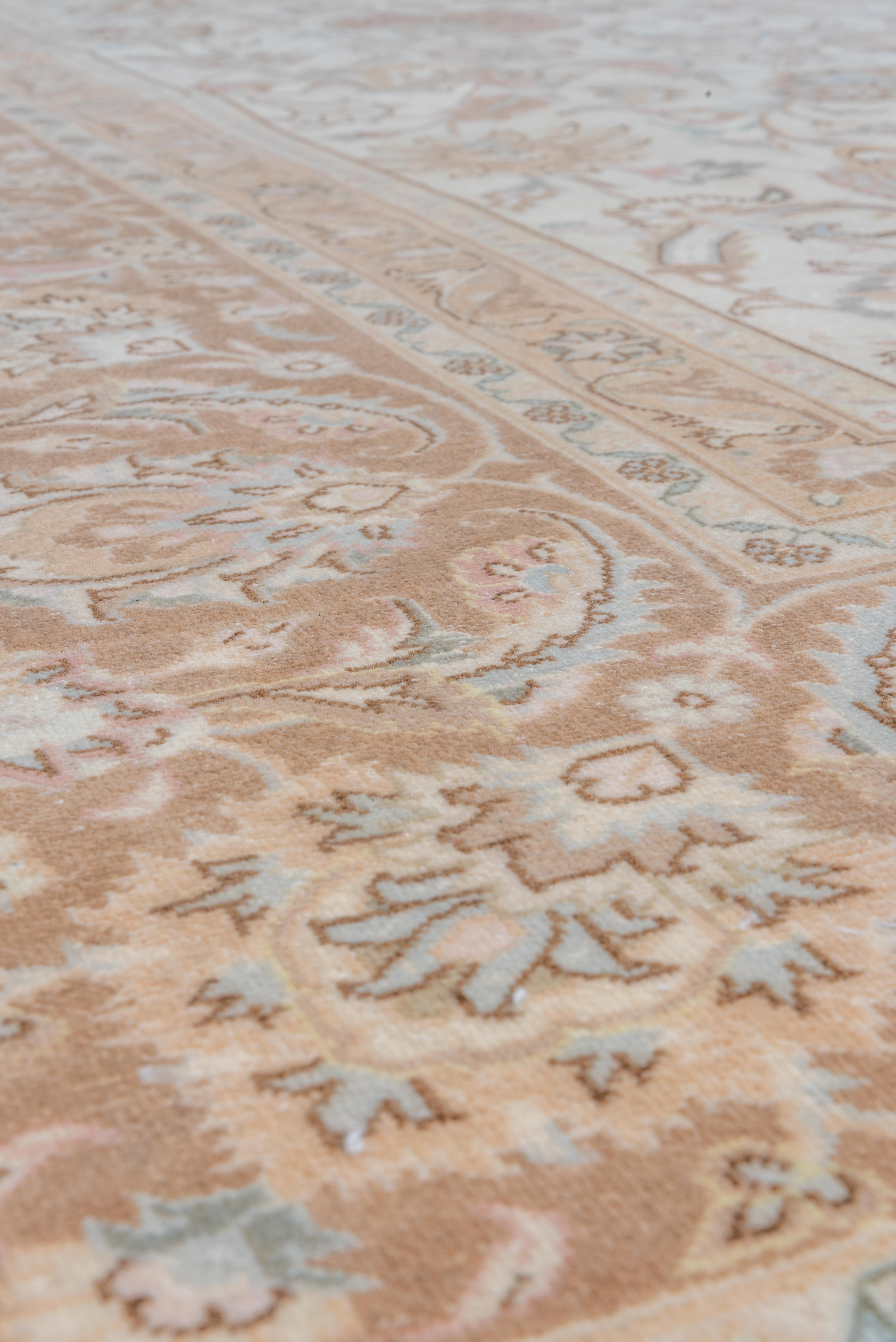 Esta antigua alfombra de Tabriz es una obra maestra de la artesanía persa, con un refinado diseño floral sobre un cálido fondo marfil. Delicadas enredaderas, palmetas en flor e intrincados arabescos se entretejen en beige suave, dorado apagado y