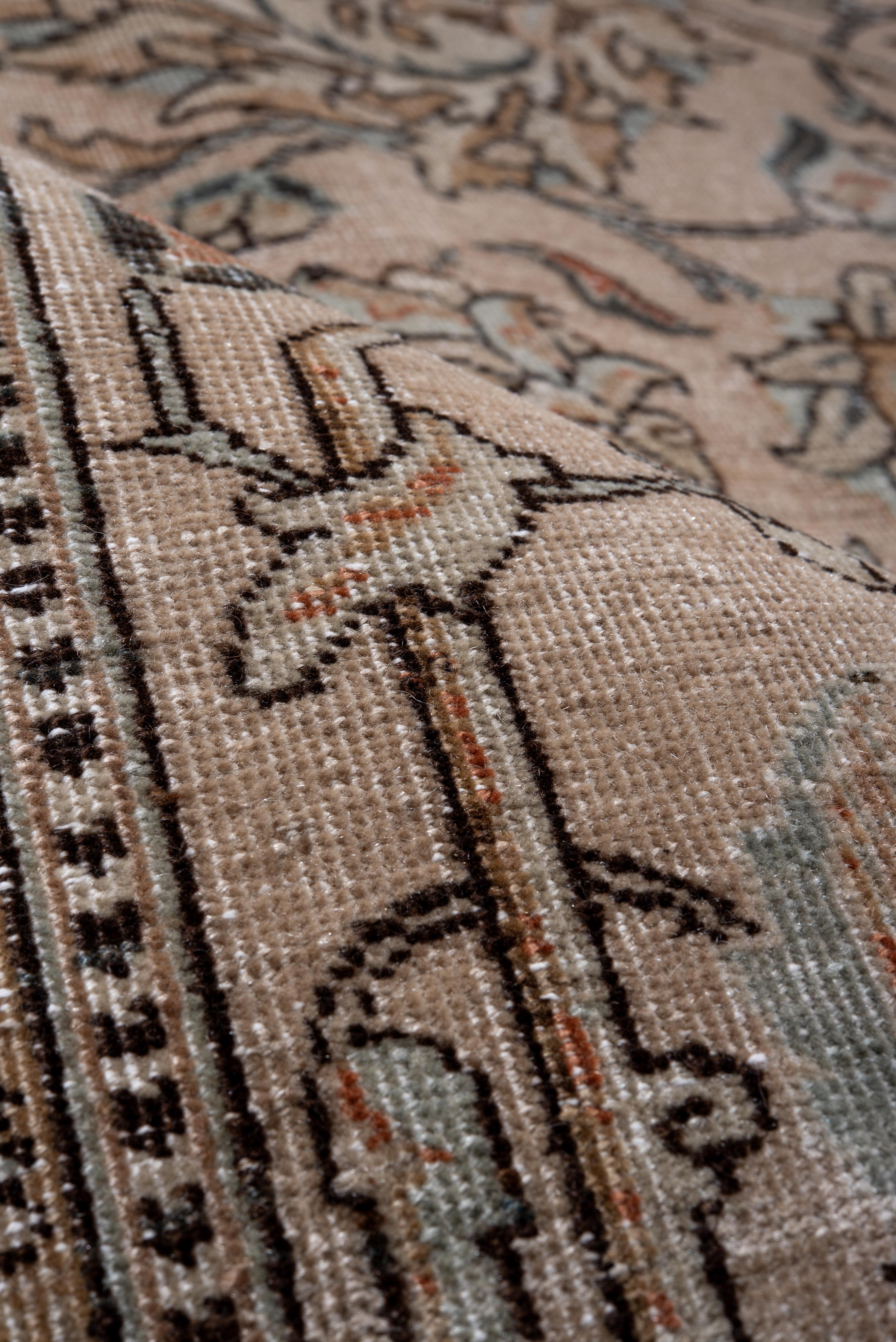 Dieser antike Täbriz-Teppich zeigt ein raffiniertes Blumen- und Rankenmuster, gewebt in einer weichen, neutralen Farbpalette aus Beige, Taupe, Elfenbein und gedämpftem Blau. Die filigranen Details aus stilisierten Palmetten, Ranken und