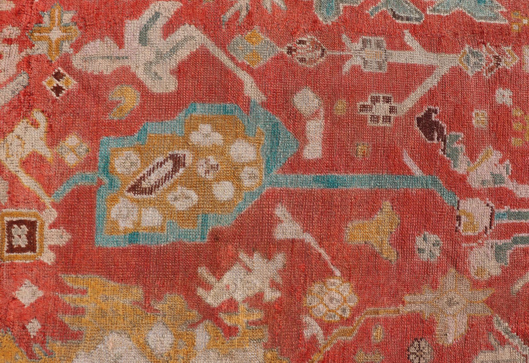 Wool Antique Turkish Oushak In Tribal Motifs in Soft Coral, Blue, Marigold, and Cream For Sale