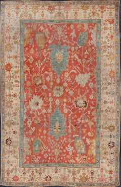 Antique Turkish Oushak In Tribal Motifs in Soft Coral, Blue, Marigold, and Cream