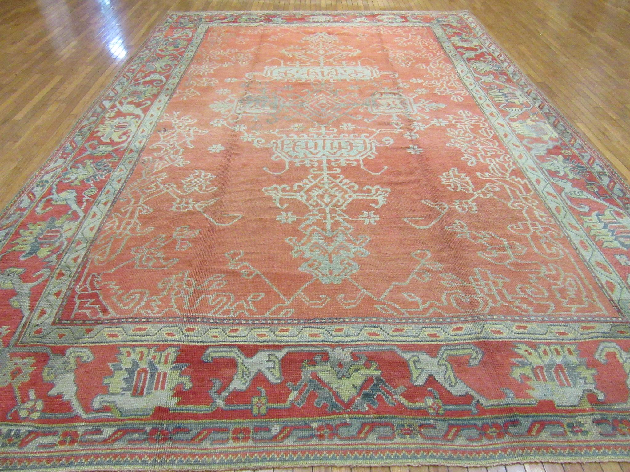 This is a large room size hand-knotted antique Turkish Oushak rug which measures 10' 8'' x 15' 2'' made with all wool and natural dyes. The rug is in very good condition.