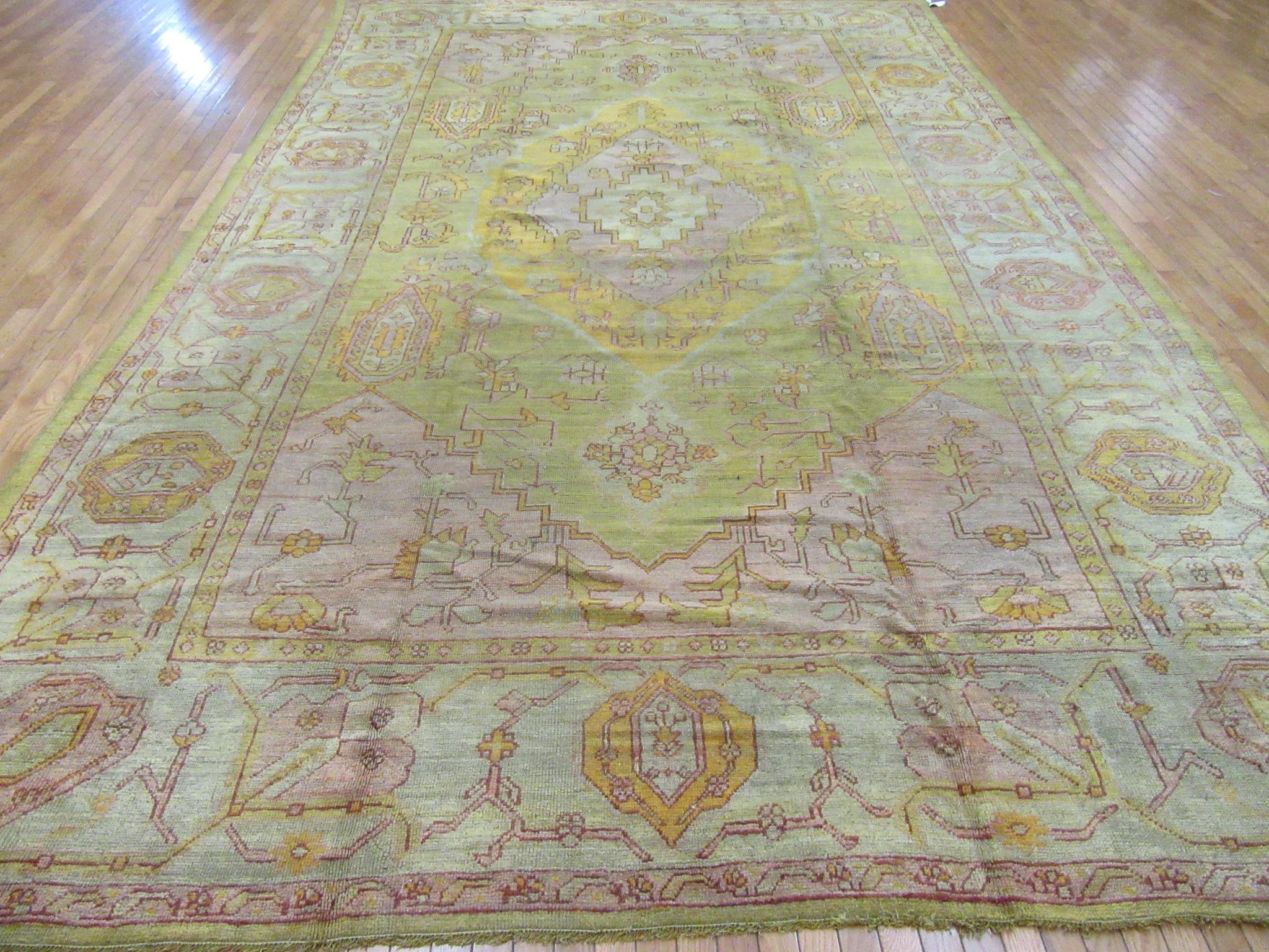 This is a finely hand-knotted antique Turkish Oushak. It has a simple pattern on a beautiful soft citrus green color background balance with warmer rose, orange and red colors. It is in great condition.