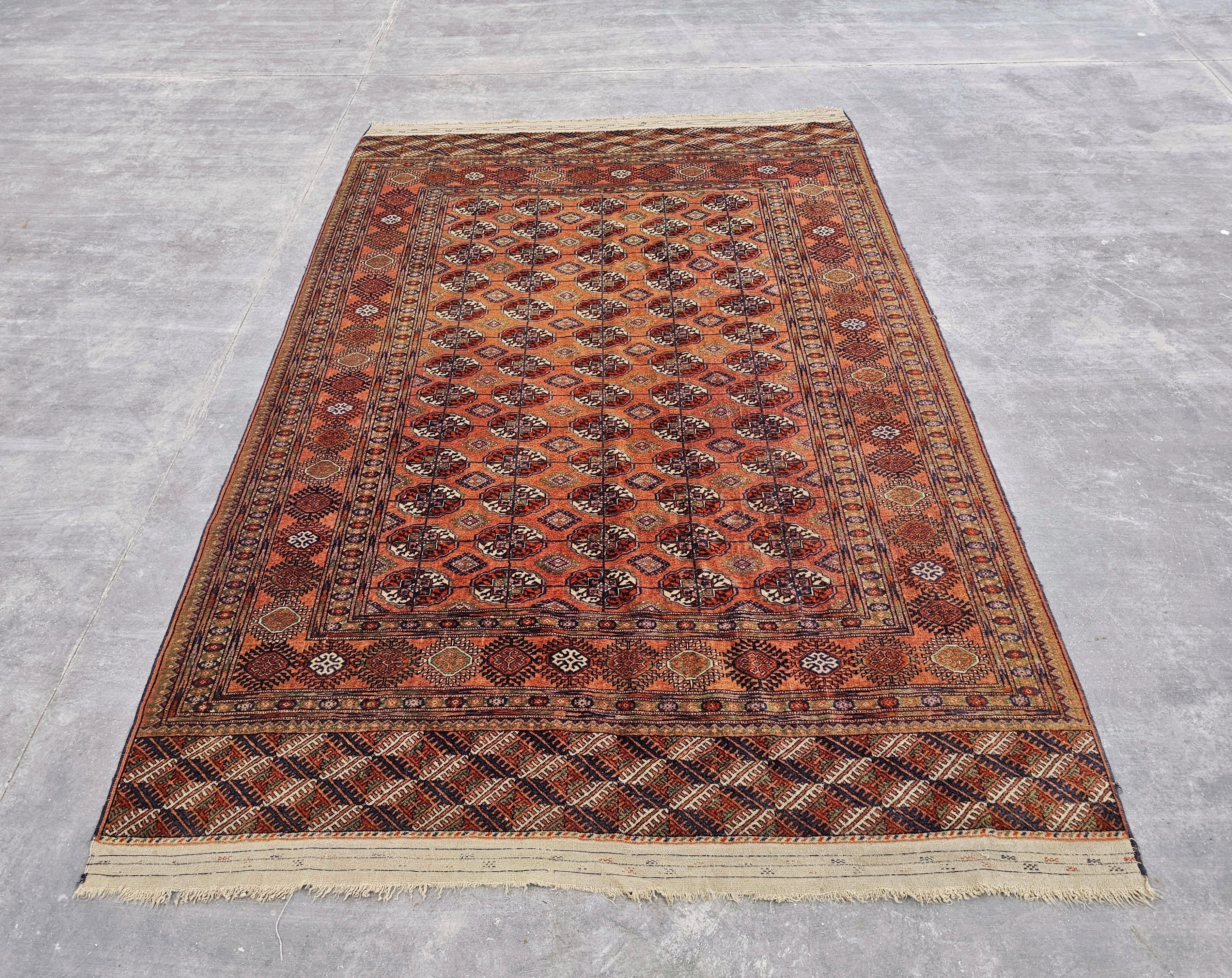 In this listing you will find a beautiful antique hand-knotted Bokhara rug. This oriental rug was made in the beginning of the 20th century in the region of Turkmenistan. It features a very rare brick orange/red-ish colour, almost the colour of