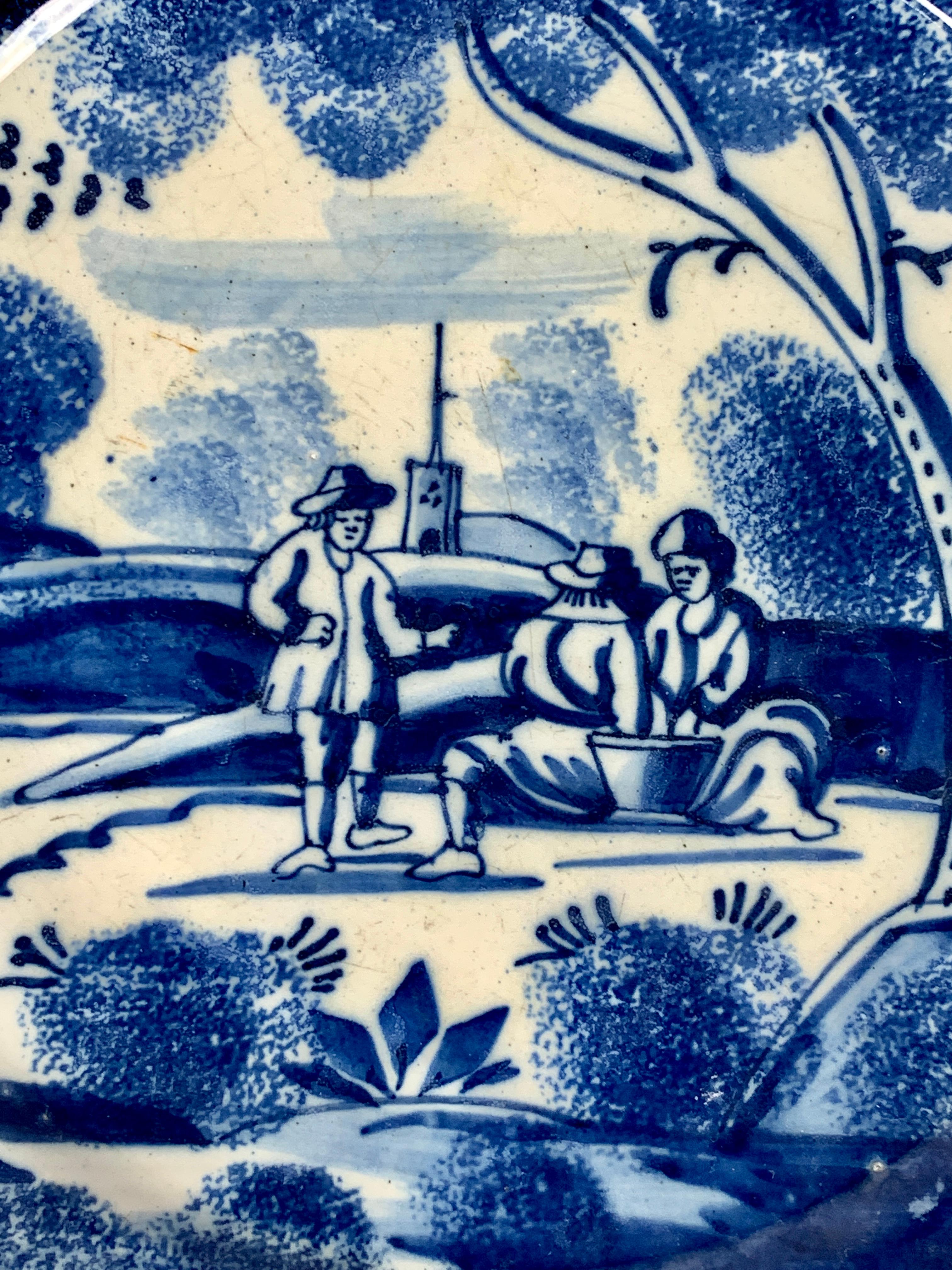 Made circa 1730-40, this 18th century Dutch Delft dish is hand-painted in cobalt blue. It is decorated with exceptional blue and white sponge work. The scene shows three Dutchmen in the countryside. The seated pair seem to be playing cards while the