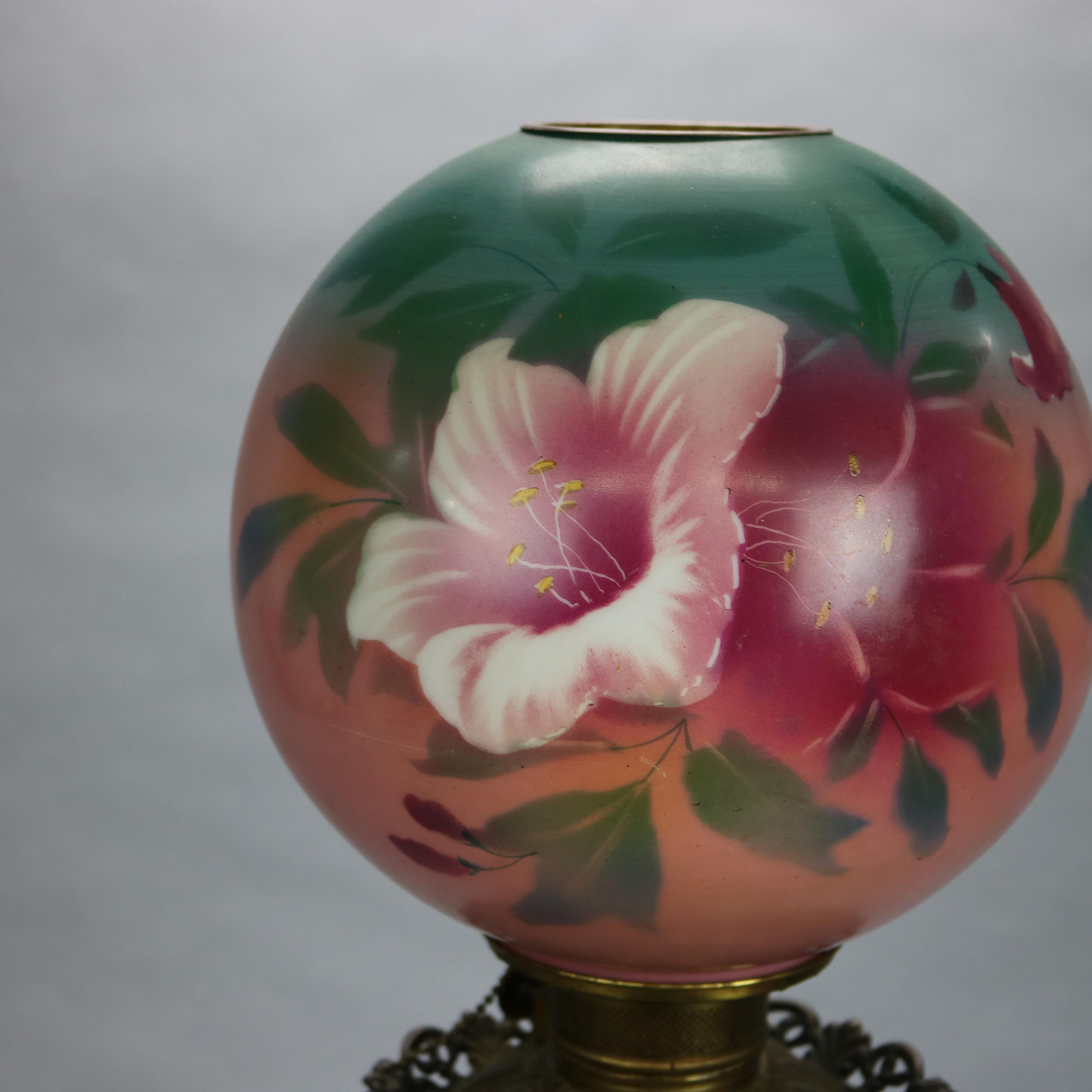 An antique gone-with-the-wind parlor lamp offers floral hand painted globe and font, raised on foliate cast footed base, electrified, c1890

Measures: 23.25