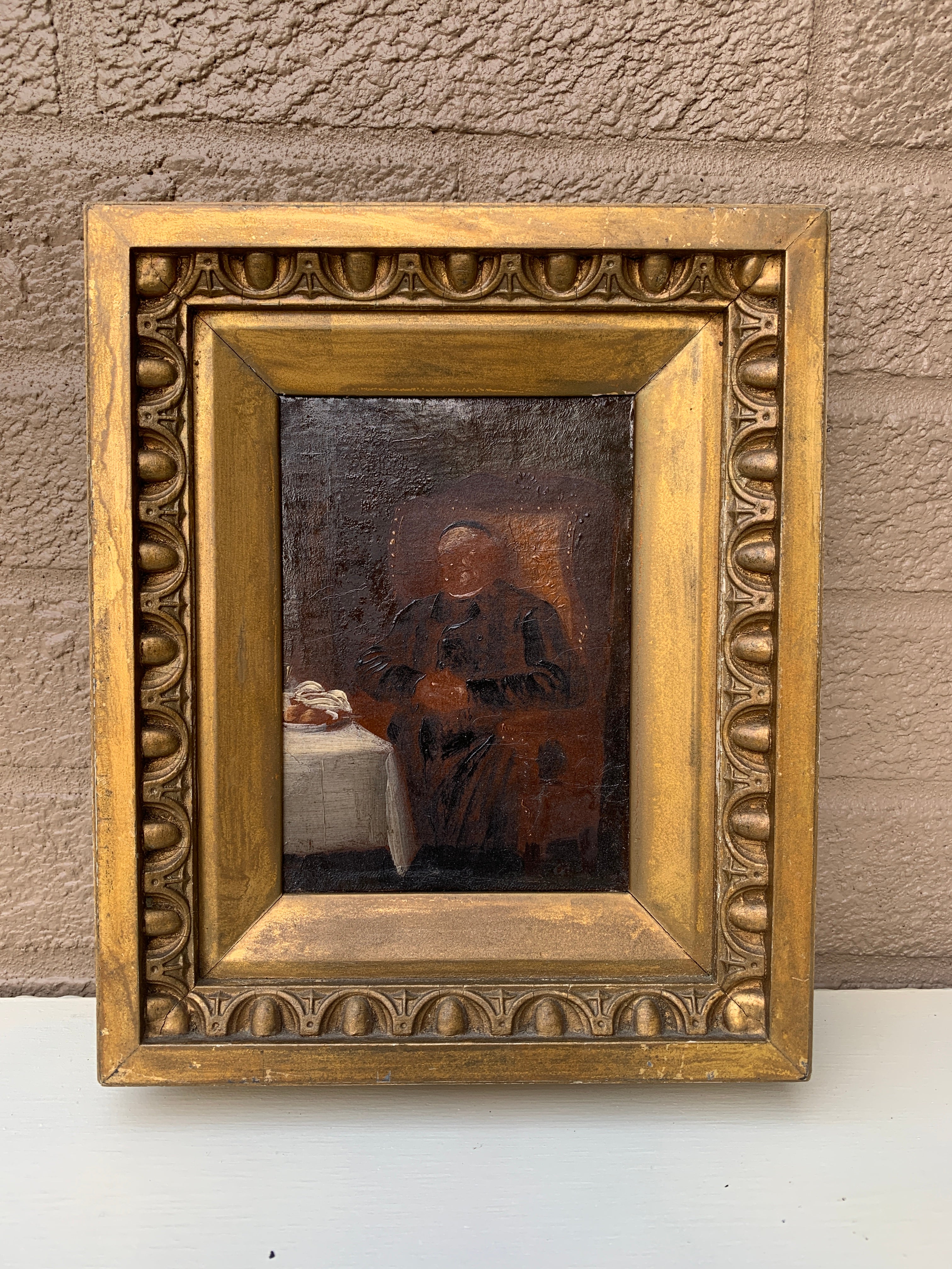 A beautiful antique hand-painted gilt wood framed oil on canvas painting of a priest sitting in a leather studded wingback chair

USA, Late 19th Century

Measures: 8.25