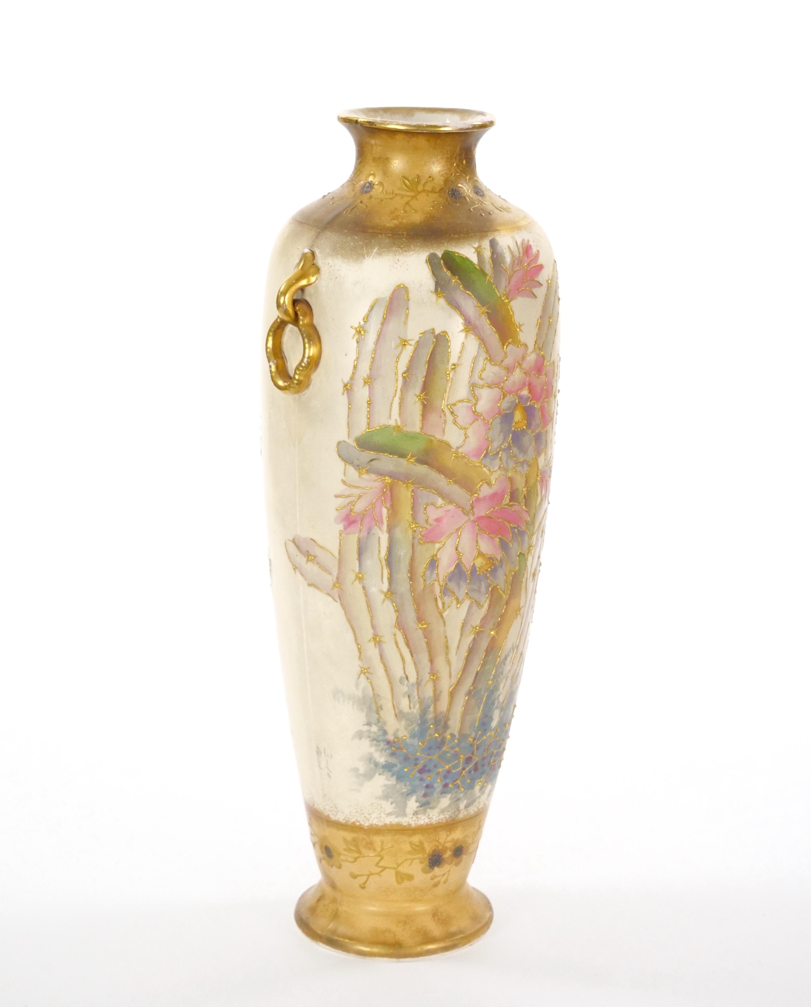 Este grandioso y elegante jarrón de porcelana fue fabricado con maestría en el siglo XIX por la apreciada empresa Royal Bonn de Alemania. Con unas impresionantes 23 pulgadas de alto y un diámetro de 7 pulgadas, este jarrón es un sorprendente ejemplo