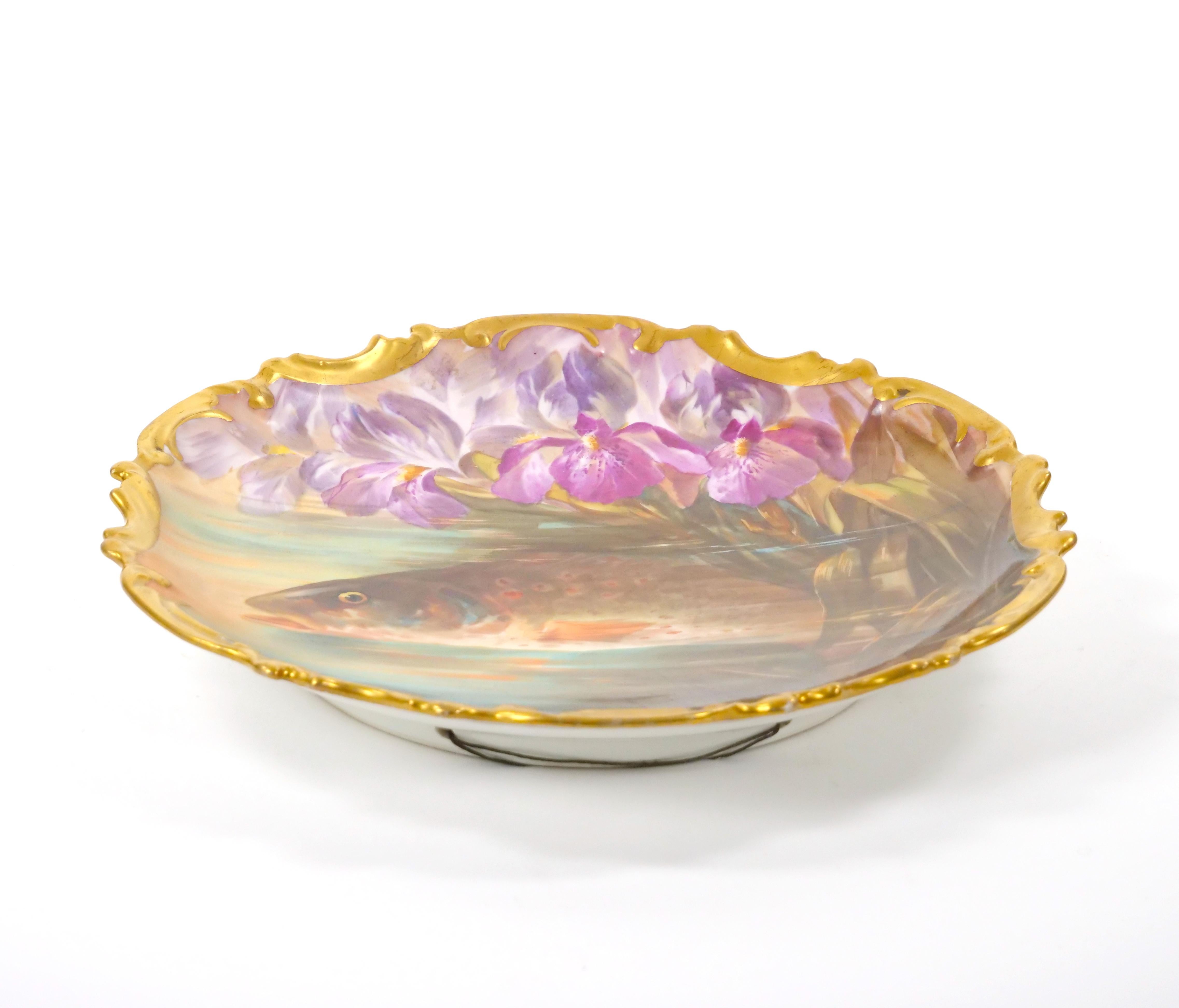 Transport yourself to the elegance of early 19th century France with this exquisite hand-painted and gilt gold decorated porcelain wall plate, crafted by renowned artisans in Limoges, France. This stunning piece is a testament to the meticulous