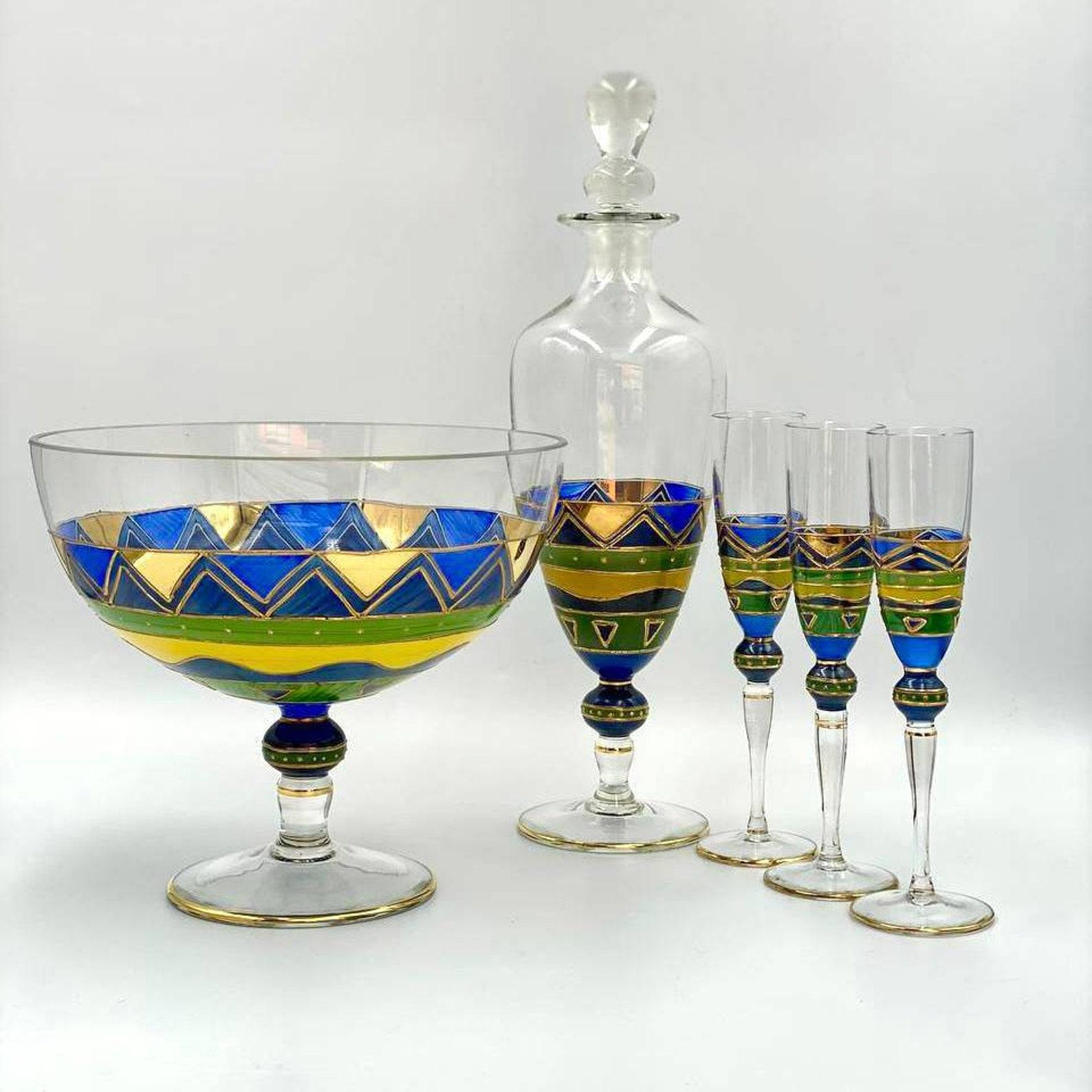 Delightful set of antique glasses, carafe and vase. 

 This beautiful 1930s antique hand painted decanter set includes a tall genie shaped decanter with stopper, three matching glass flutes and a vase. 

 The set is decorated with enameled