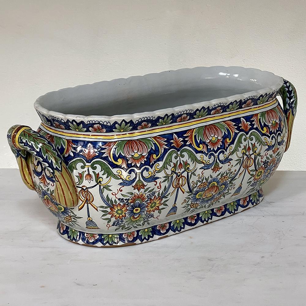 Antique hand-painted Jardiniere from Rouen is a vibrantly colored, classically styled planter that adds visual delight to any room, regardless of whether one has placed fresh flowers in it or not! The design is an elongated urn form that dates back