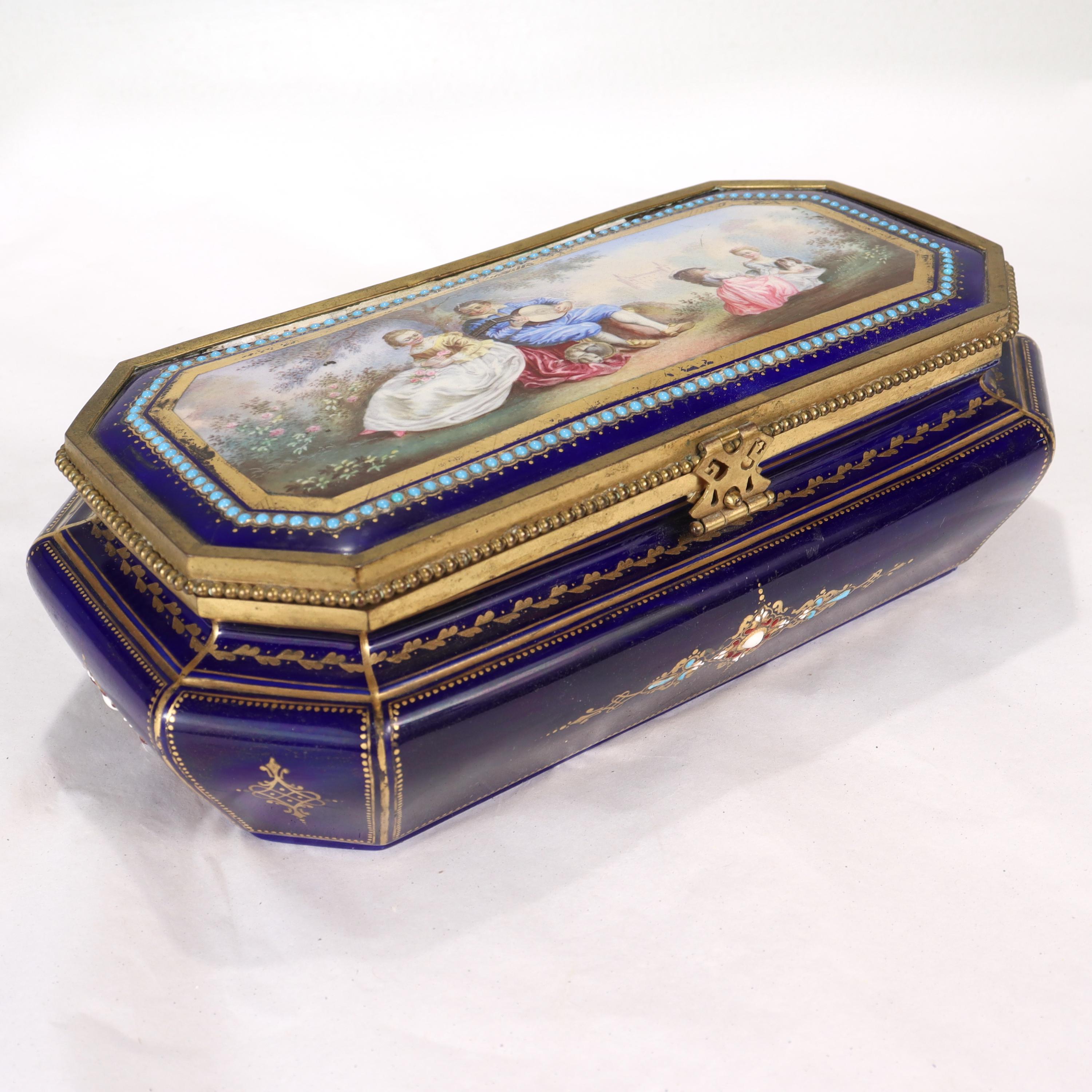 A very fine antique Sevres style French porcelain dresser box or casket.

With extensive gilt highlights and turquoise, red & white enamel jeweling throughout.

Decorated to the lid with a finely hand painted scene of a man playing the lute for