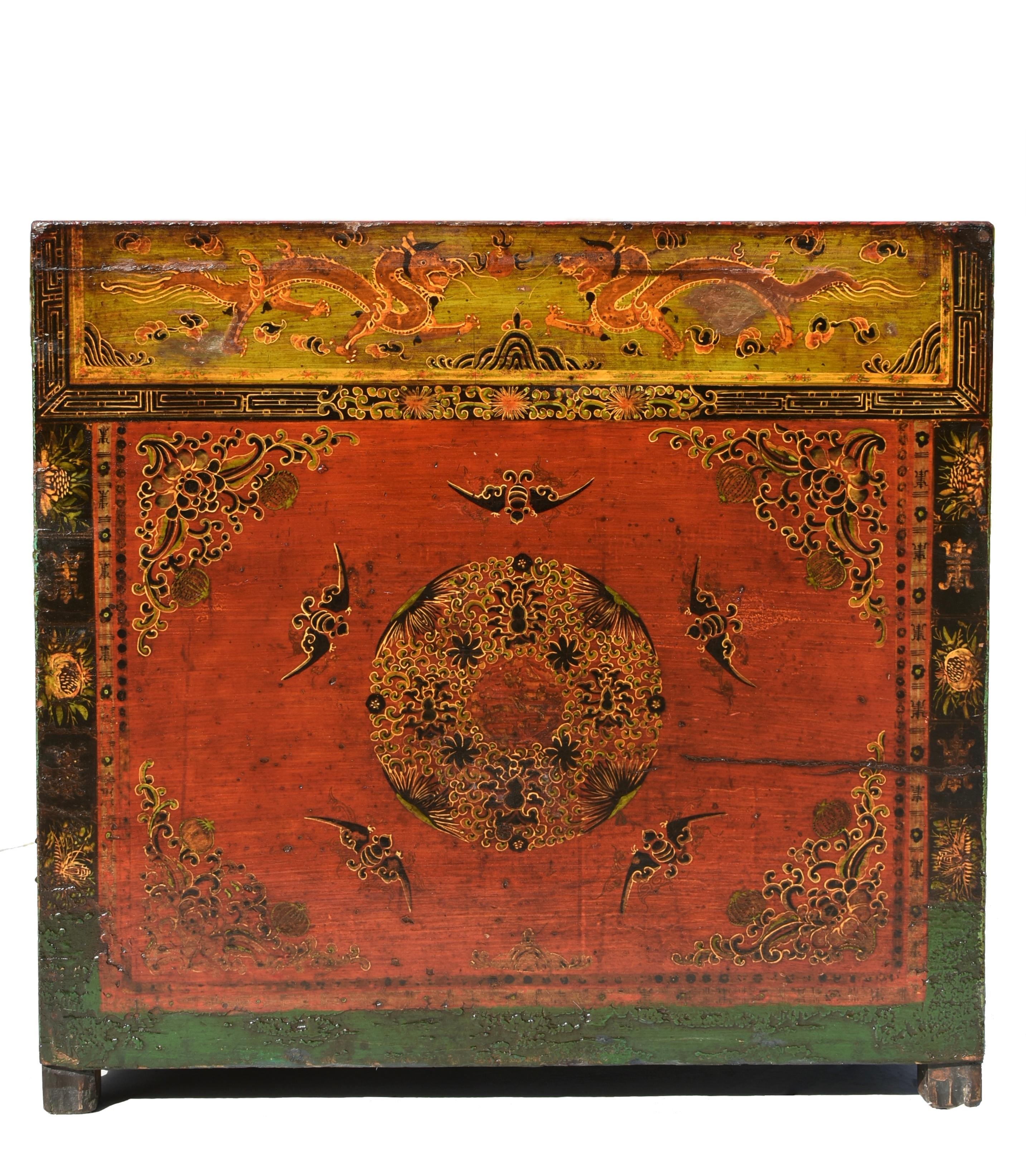 Rare coffre mongol en bois massif, peint à la main, datant du XIXe siècle. L'avant présente un magnifique médaillon floral entouré de cinq chauves-souris, symbolisant la bonne fortune et la beauté. Aux quatre coins, on trouve des pivoines et des