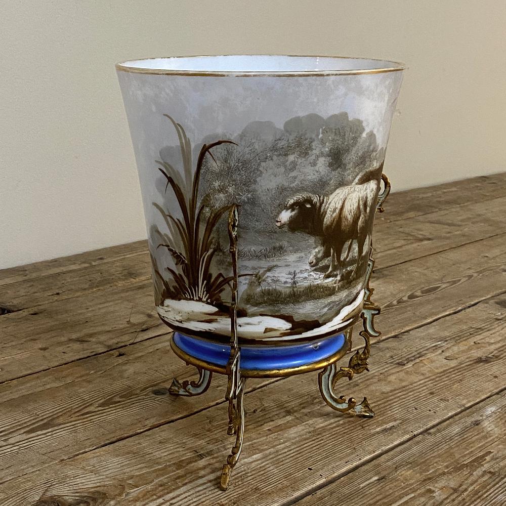 Antique hand-painted opaline footed vase will make a delightful addition to your decor, with subtle gray tones in the background and warm browns and golds used to depict a ram and ewe in a naturalistic setting. The gold trim on the rim at top and
