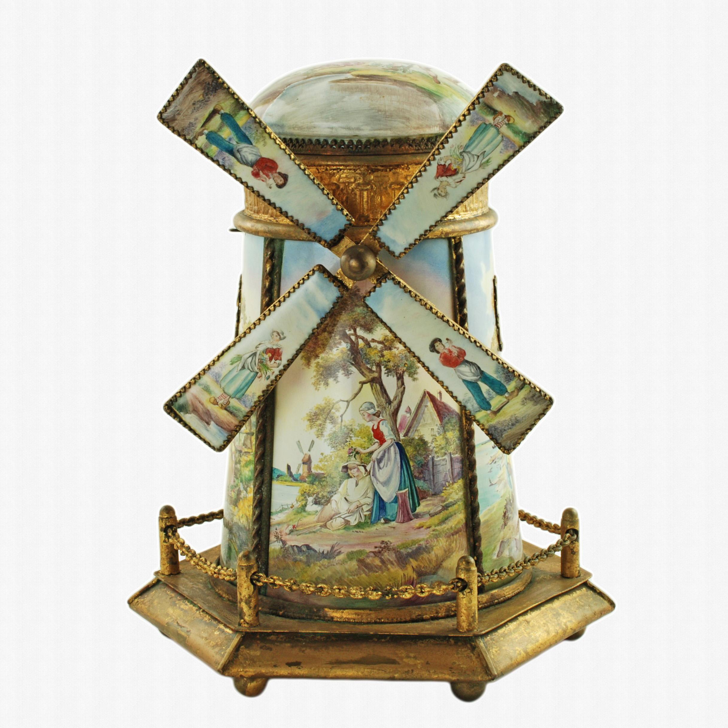 This elegant antique musical jewelry box has been made in the form of a windmill with a removable domed roof.  The roof lifts to reveal a shallow circular burgundy velvet-lined compartment. The exterior of the windmill bears four large rectangular