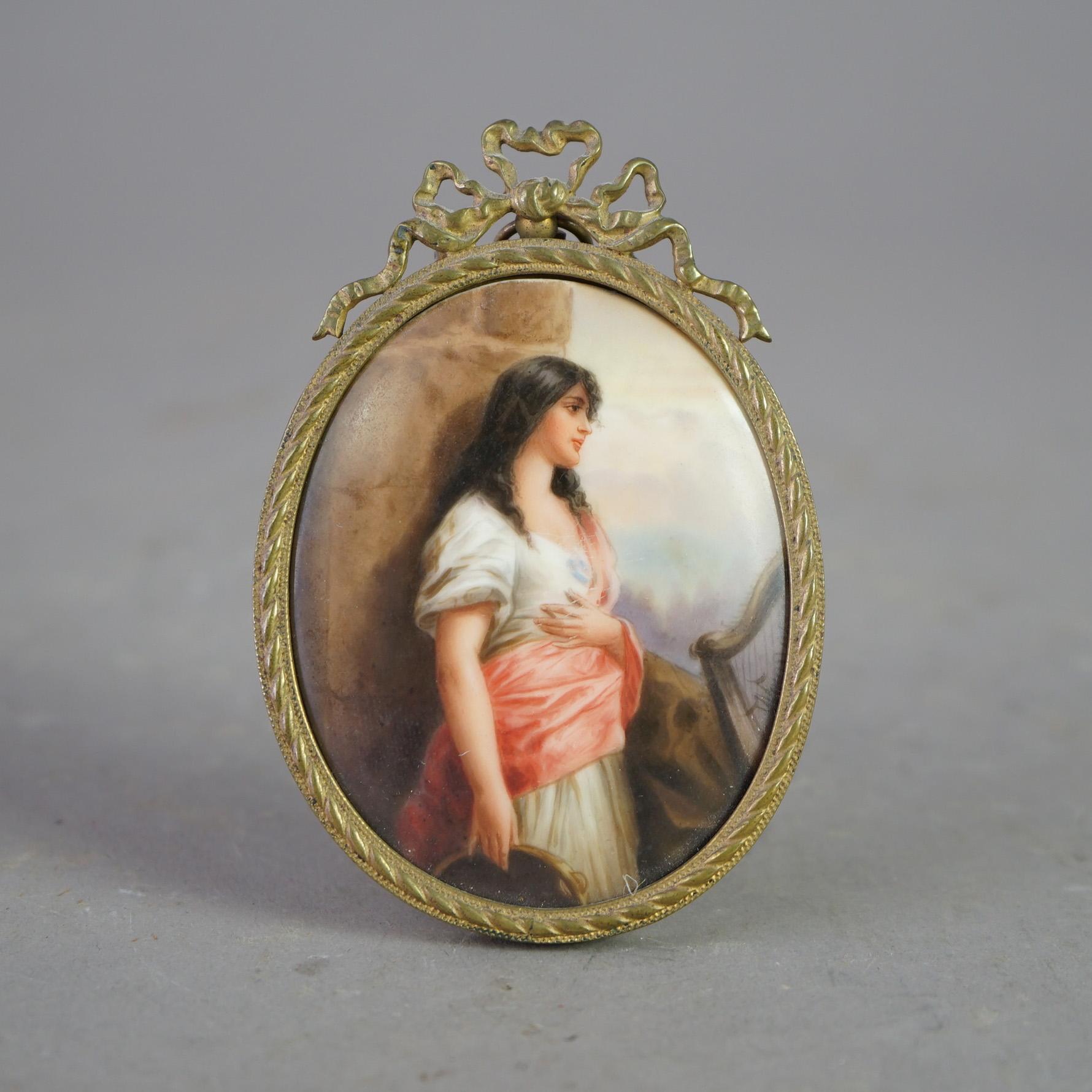Antike, handbemalte Porzellanplatte mit dem Porträt einer jungen Frau, sitzend in einem Rahmen aus gegossenem Messing in Form eines Bandes, 19.

Maße - 4 