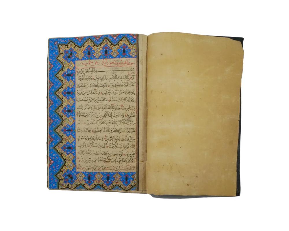 An antique hand painted Quran book with manuscripts. Black genuine leather cover. A beautiful antique edition with hand painted design. Circa mid to late 19th century. The text of the holy book in red and black in Arabic is framed in a red outline.