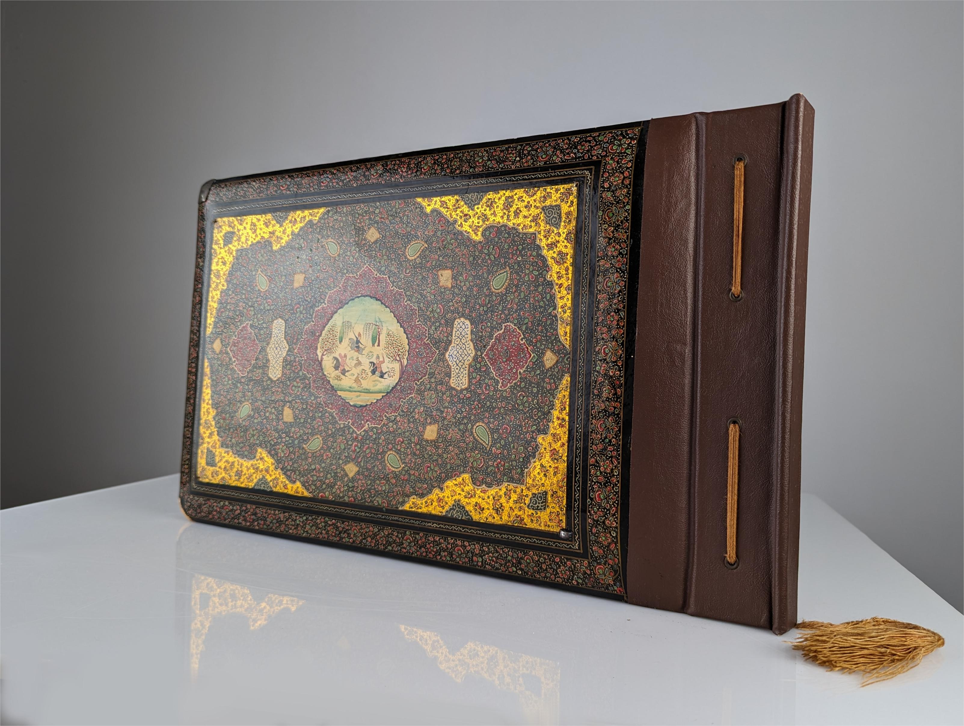 Middle Eastern photo album from the 19th century, Qajar period, hand-painted lacquered enamel with silver covers and decorations. Enameled central plates painted on both sides representing a horse hunt and a palace, silver corners and frames and
