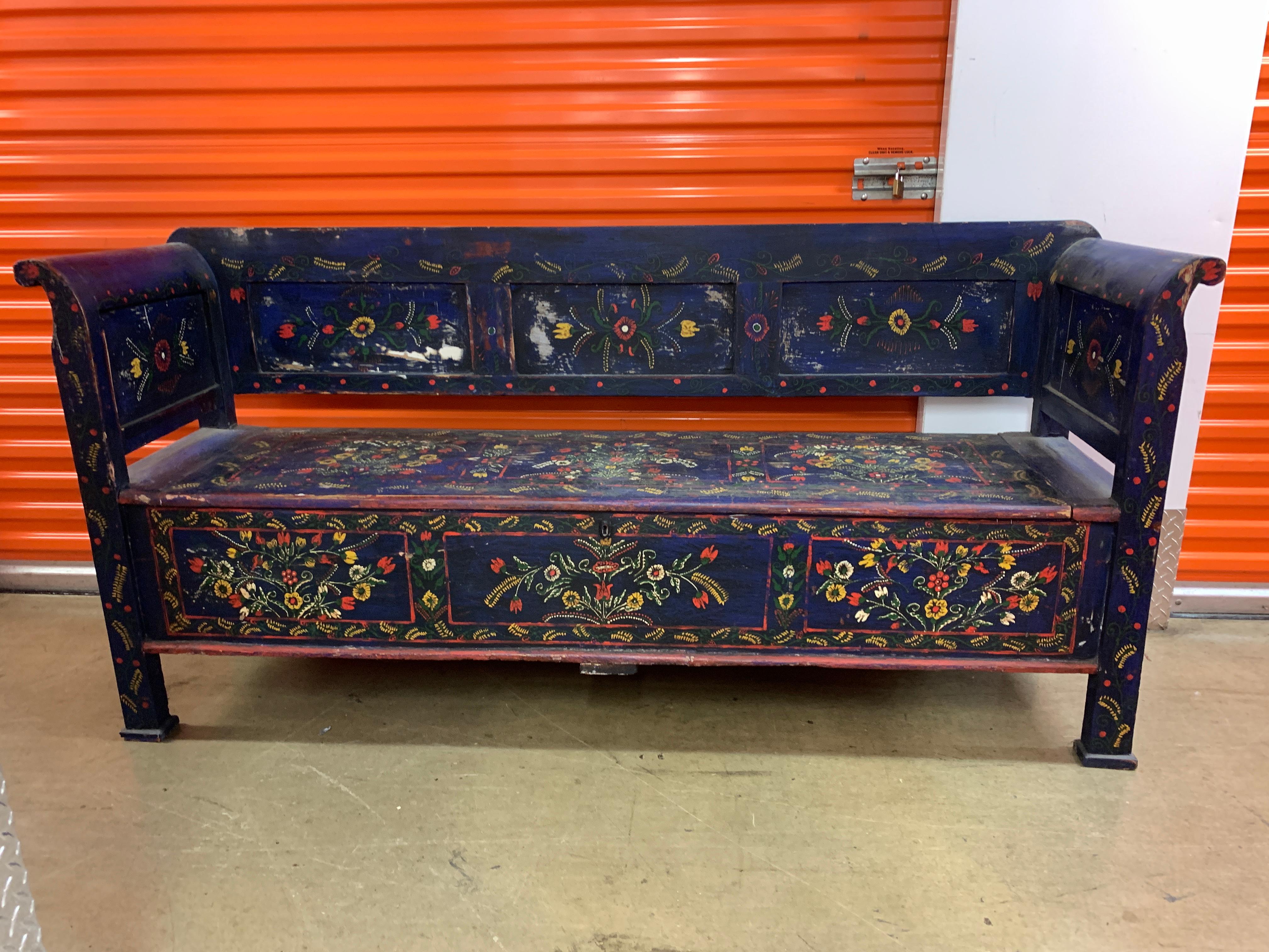 An absolutely striking antique Swedish bench with beautifully hand painted floral designs and a vibrant indigo blue that may register as ultra violet. This Swedish bench not only celebrates the traditional floral display but incorporates