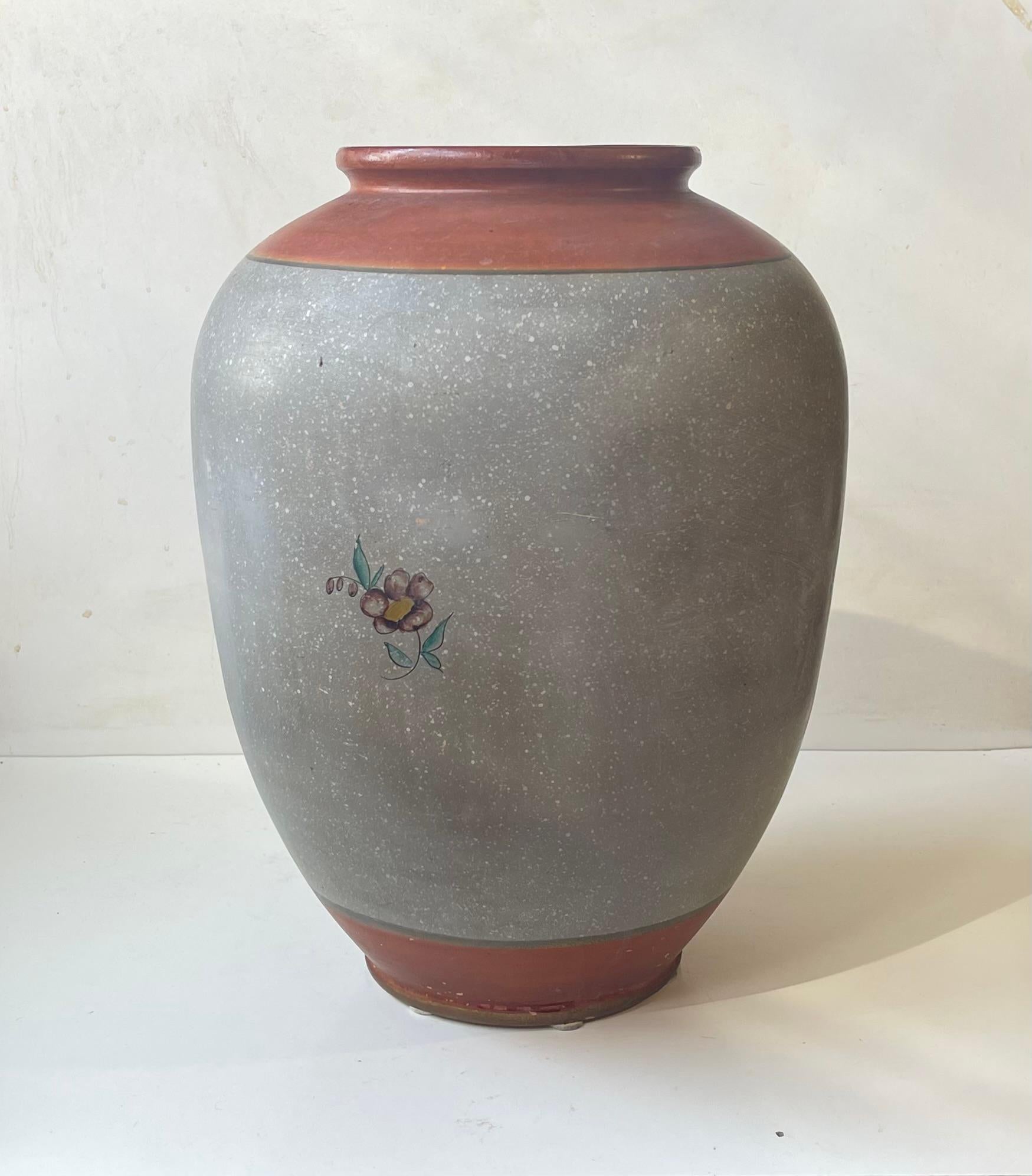 Vase monumental en terre cuite et faïence, entièrement émaillé dans des tons gris poussiéreux et caramel. Décoré de fleurs peintes à la main. Conçu et fabriqué par Knabstrup au Danemark dans les années 1910 ou 1920. 

Dimensions : H : 42 cm, D : 28