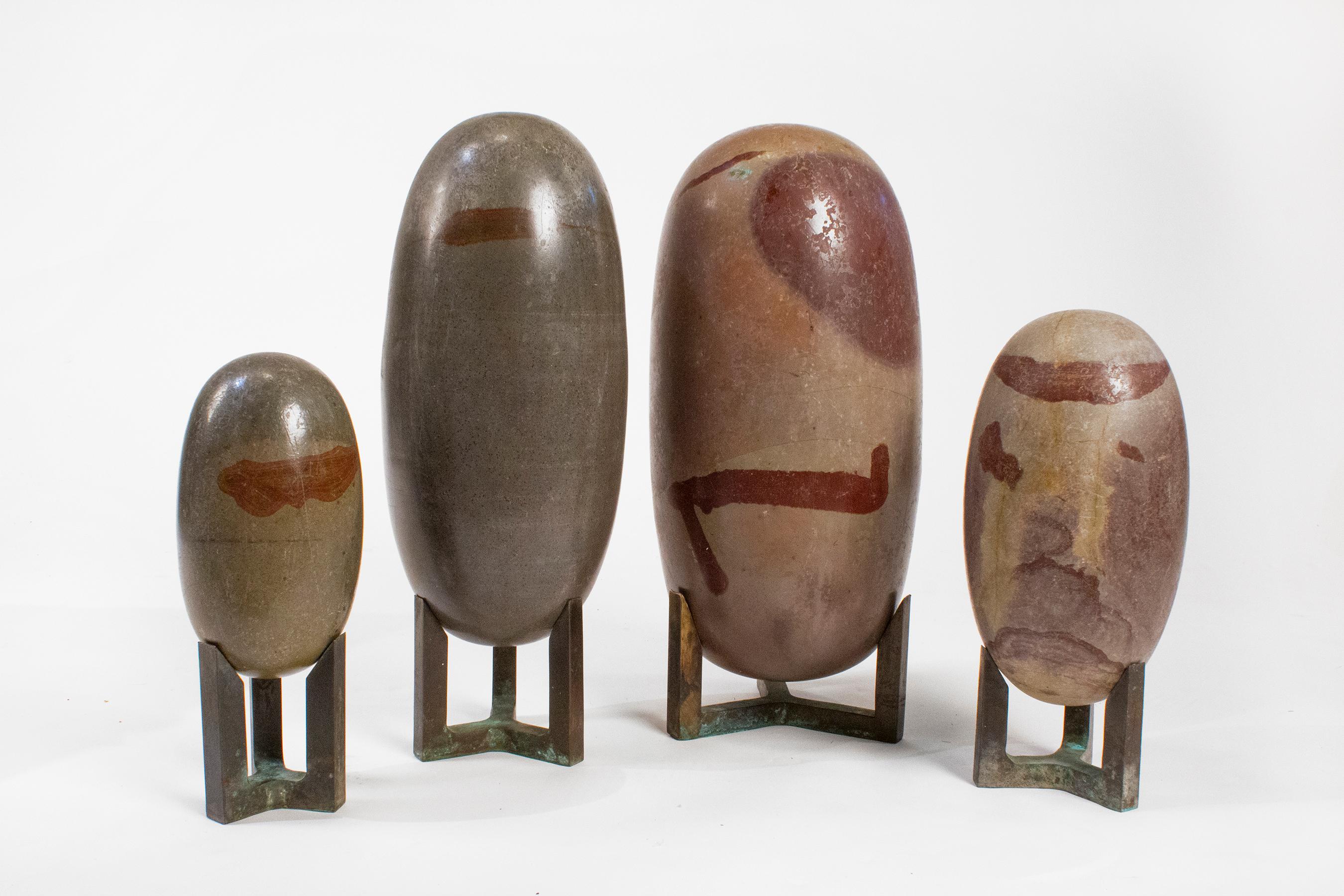 A beautiful and substantial collection of four lingam stones on bronze stands with the tallest stone measuring 18”,  from the Narmada River in India.

They are naturally formed of a mineral called CRYPTOCRYSTALLINE QUARTZ, with abstract shaped iron