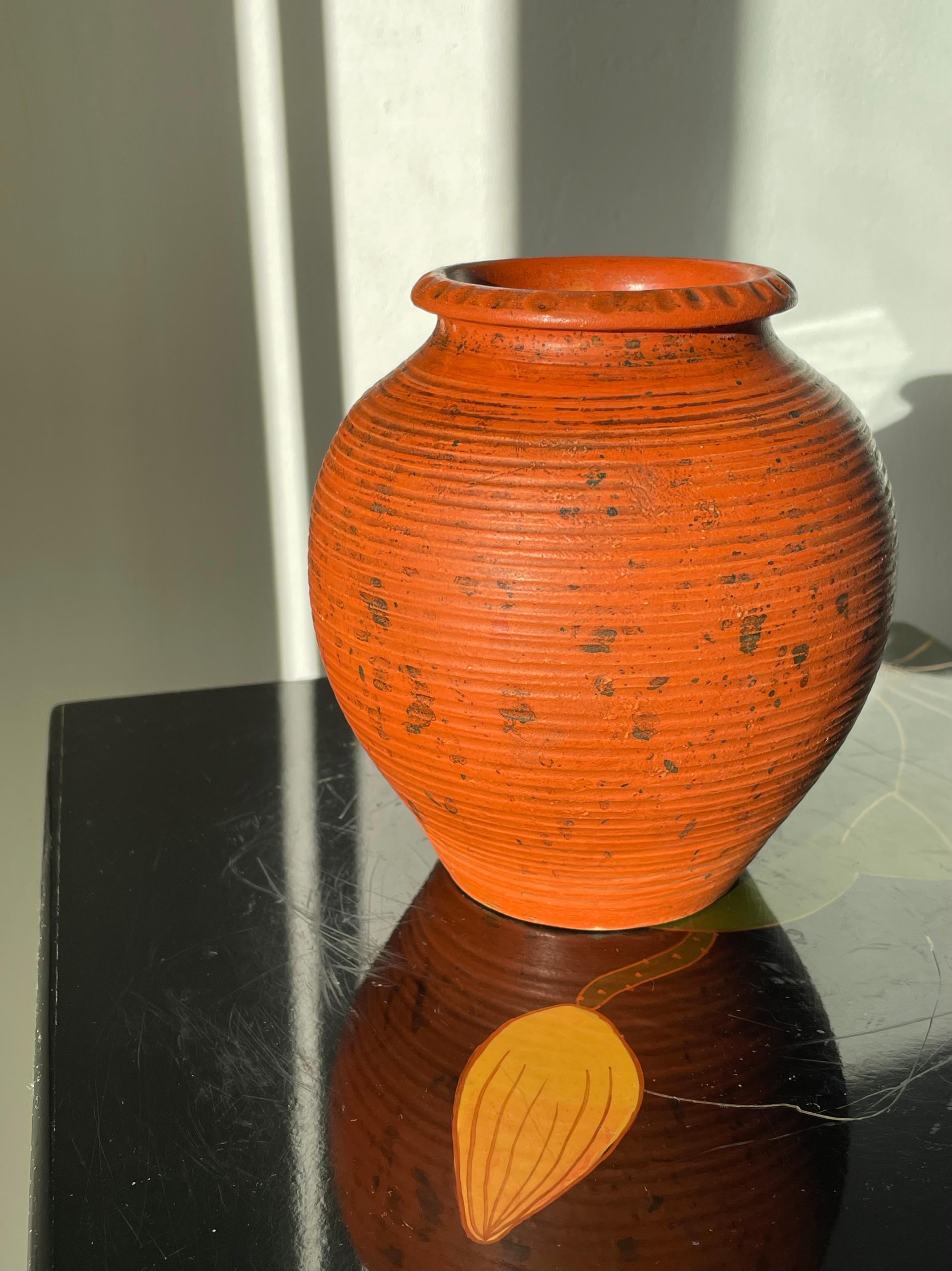 Antique 1920s hand-thrown ceramic art nouveau vase attributed to Knabstrup Keramik. Wavy edge with round indentations over the rustic, chubby belly with black speckled warm orange matte glaze. A handmade hundred year old item in beautiful vintage