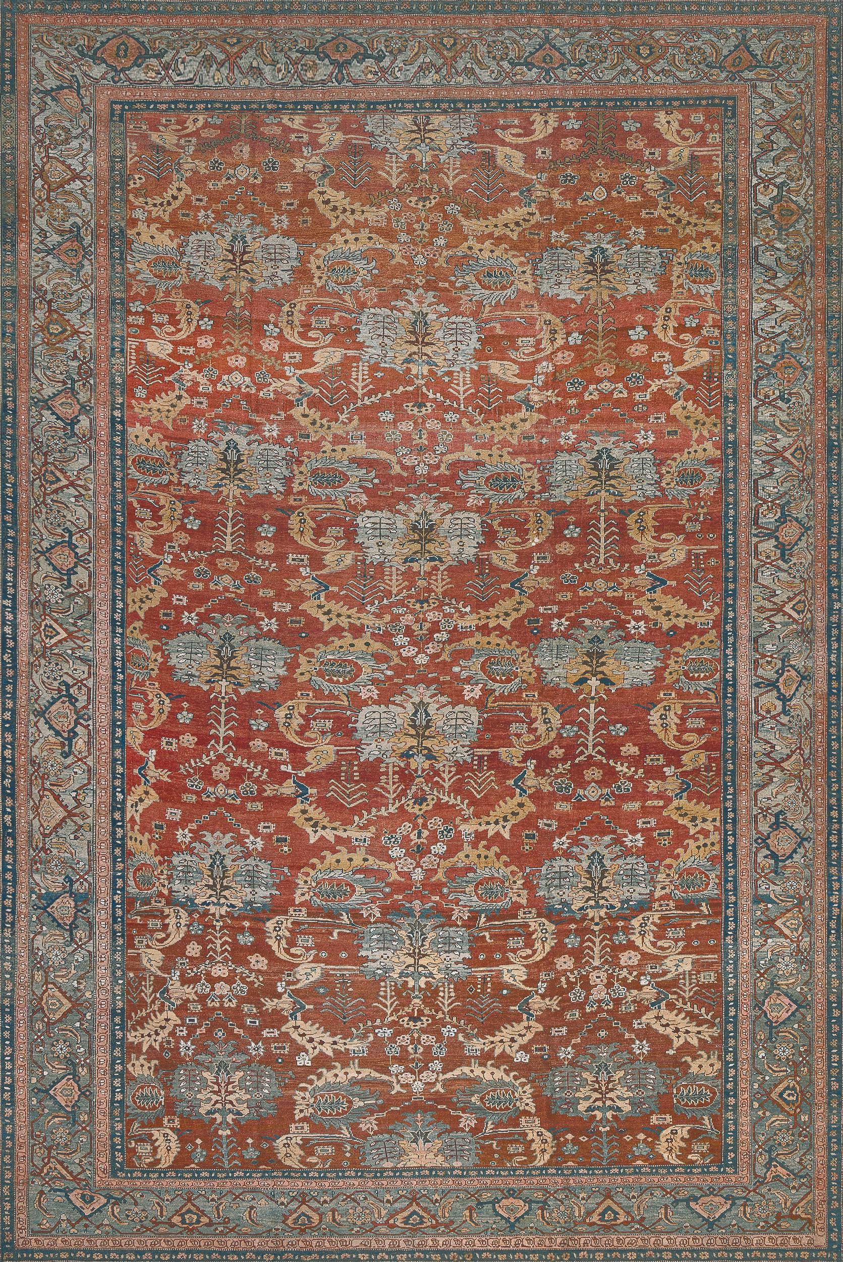 This traditional hand-woven Persian Bakhshaish rug has a shaded rust red field with bold stylized palmettes issuing stylized fronds and floral vines, in a magnificent shaded sky blue turtle palmette border, between delicate floral stripes.