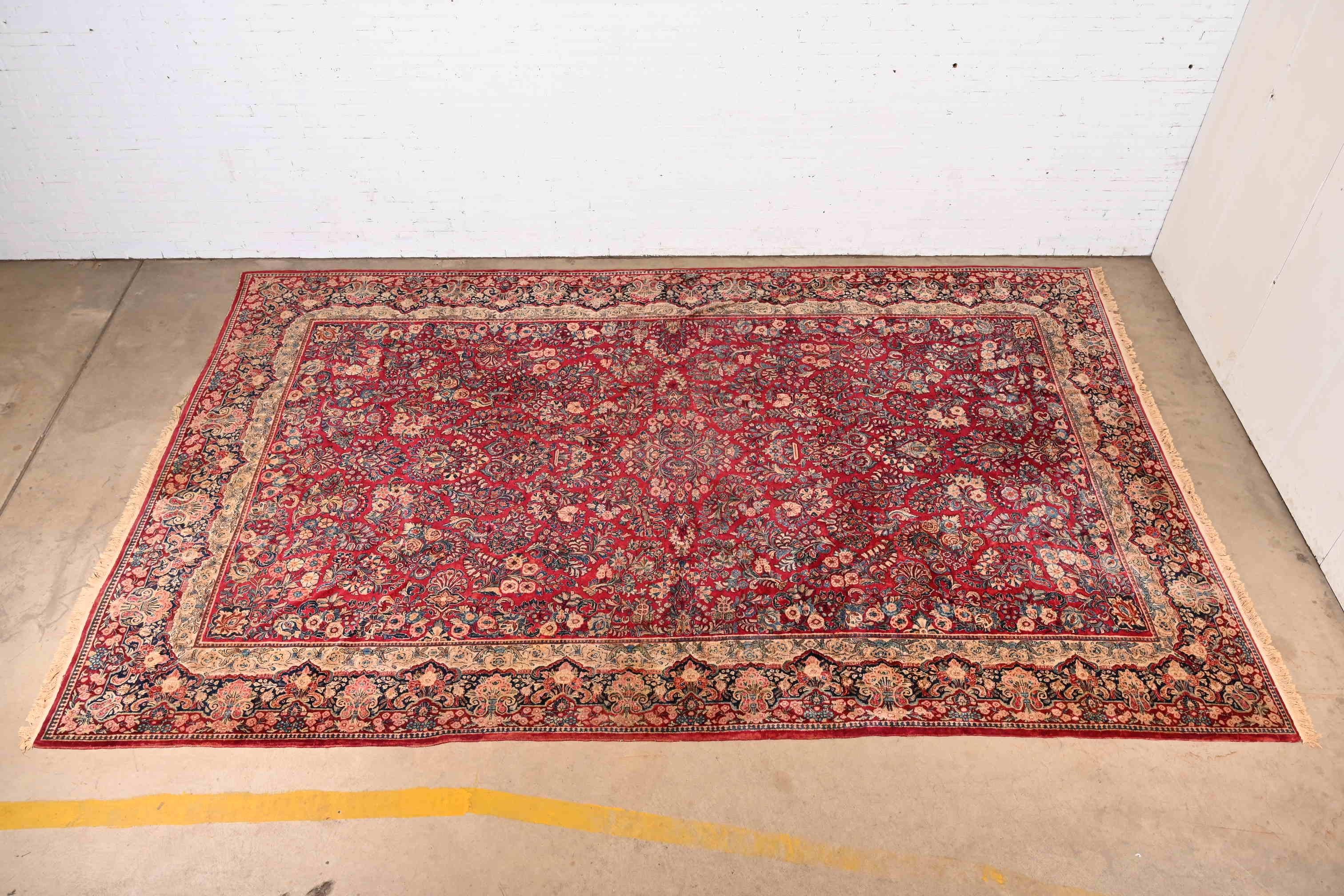 Ein prächtiger antiker handgeknüpfter persischer Sarouk Wollteppich in Zimmergröße

CIRCA 1930er Jahre

Klassisches Blumendesign mit den vorherrschenden Farben Rot, Blau und Elfenbein.

Maße: 10'7