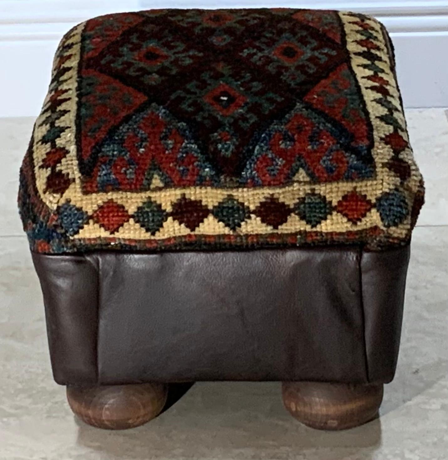 Funky foot stool made of wood, upholstered with beautiful hand woven antique Kurdish bag face collectable rug , repeating geometric Diamond motifs . firm, and great decorative small stool.
 